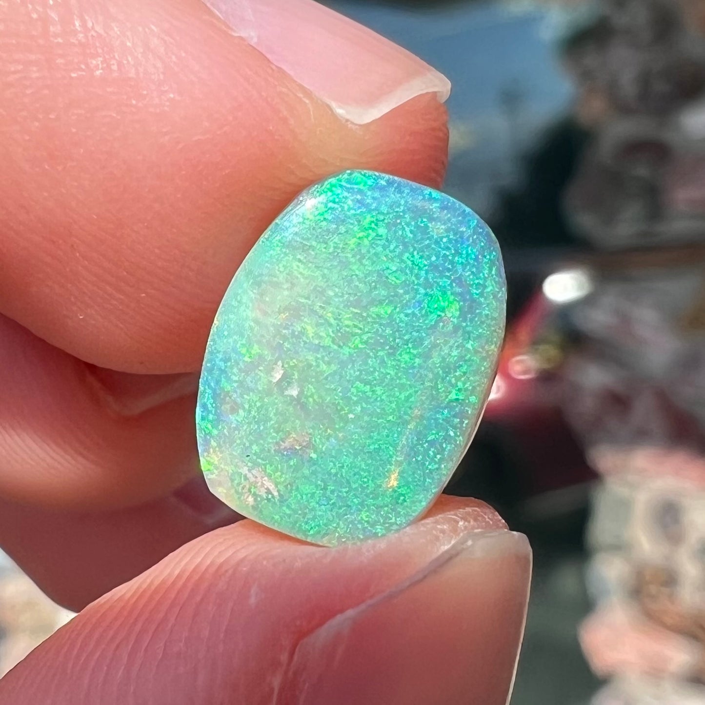 A 2.40ct barrel shaped Lightning Ridge semi-crystal opal. The stone has blue and green colors.