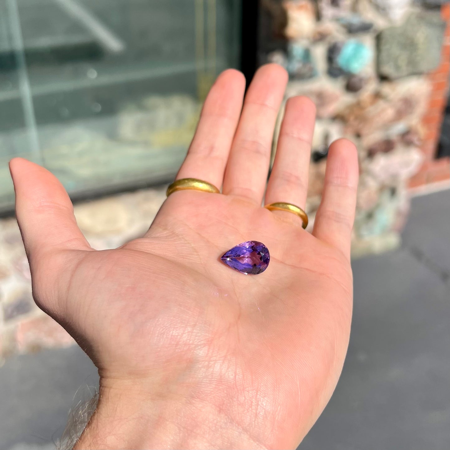 A loose, pear shaped amethyst gemstone. The stone is a medium purple color.