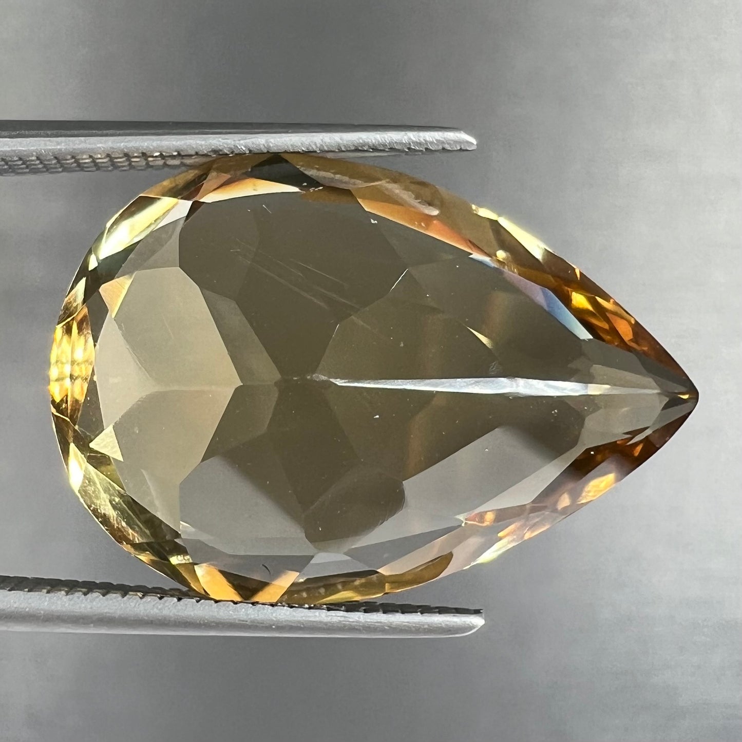 A loose, golden yellow pear shaped citrine stone.