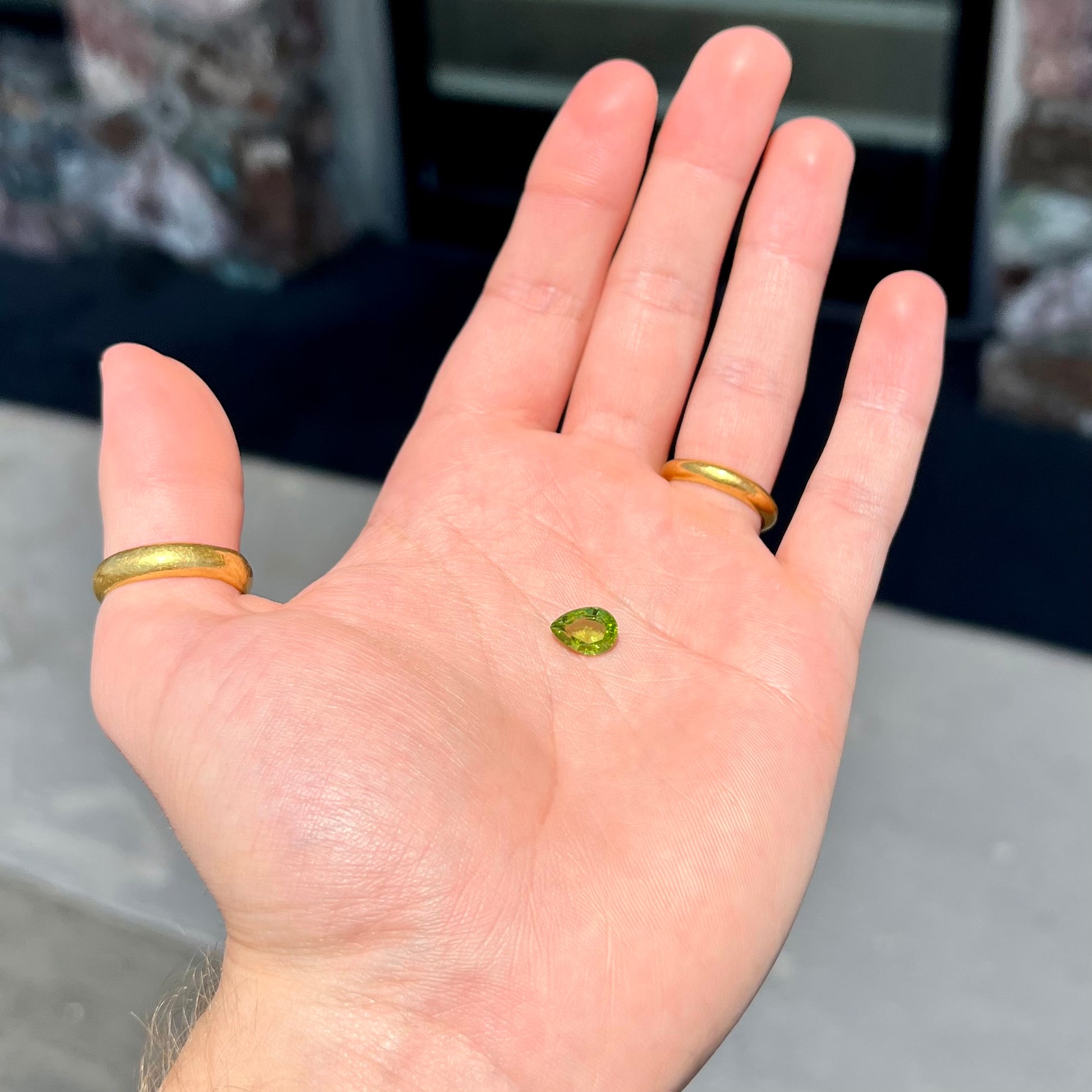 A loose, yellow green, pear shaped peridot gemstone.