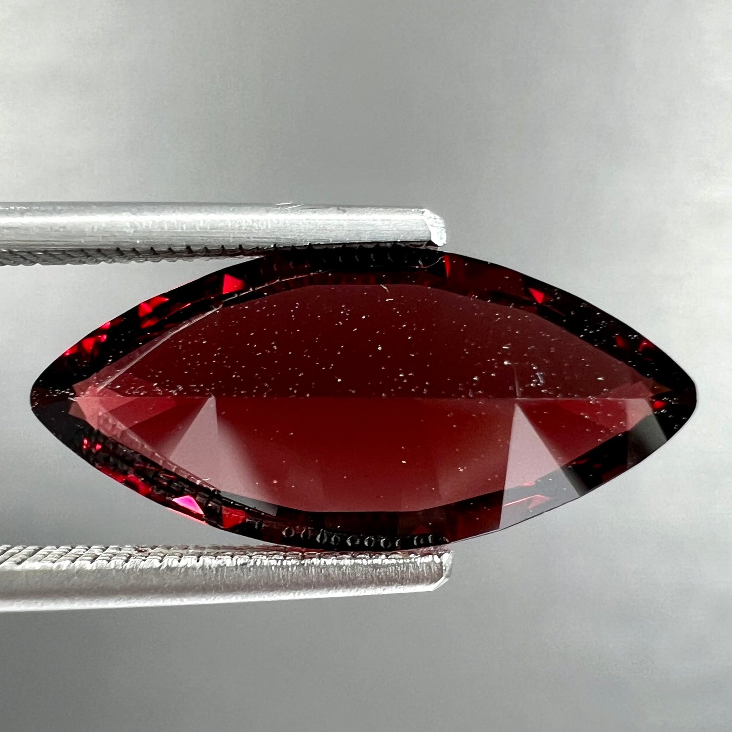 A faceted marquise cut red pyrope garnet stone.