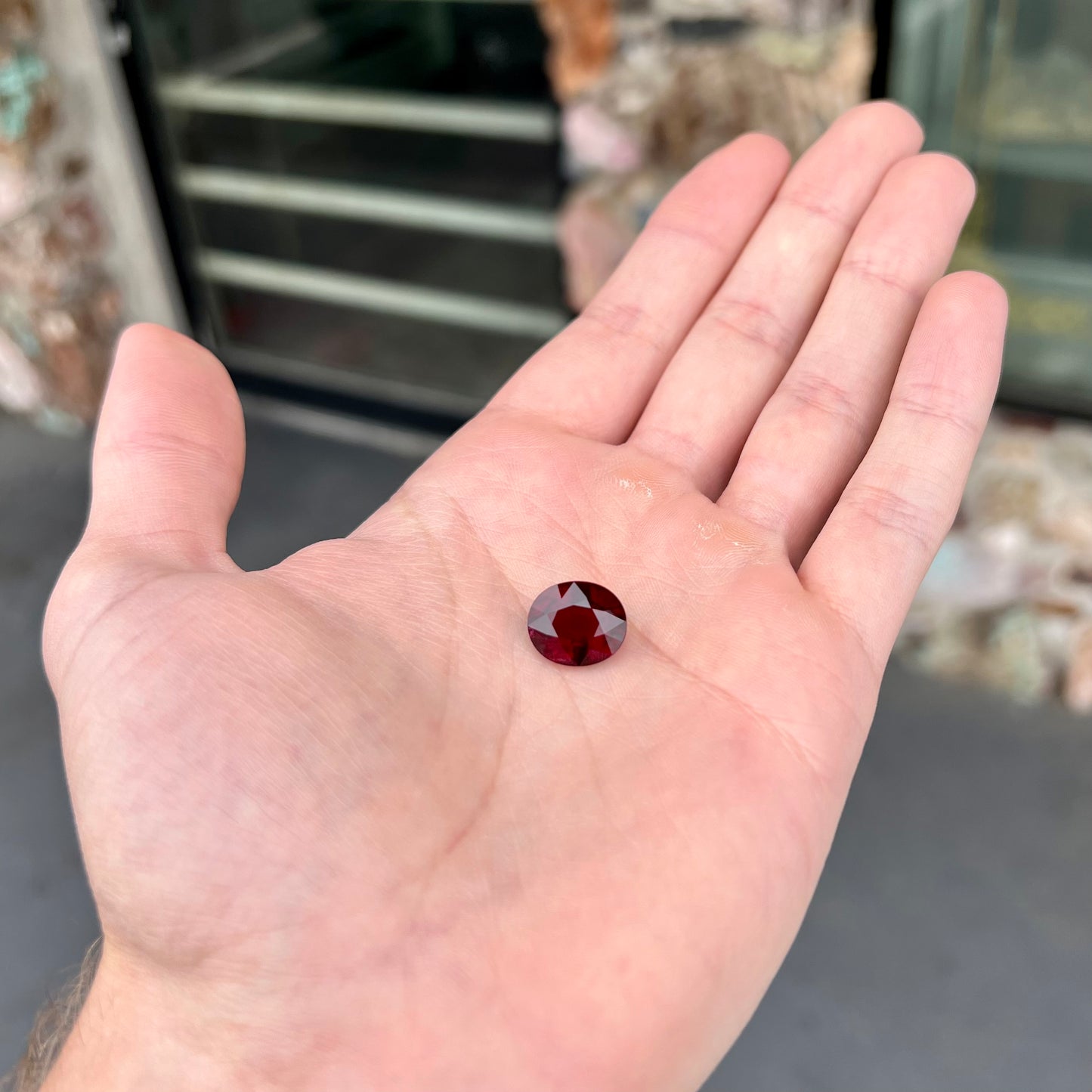 A loose, oval cut purplish red rubellite tourmaline stone.