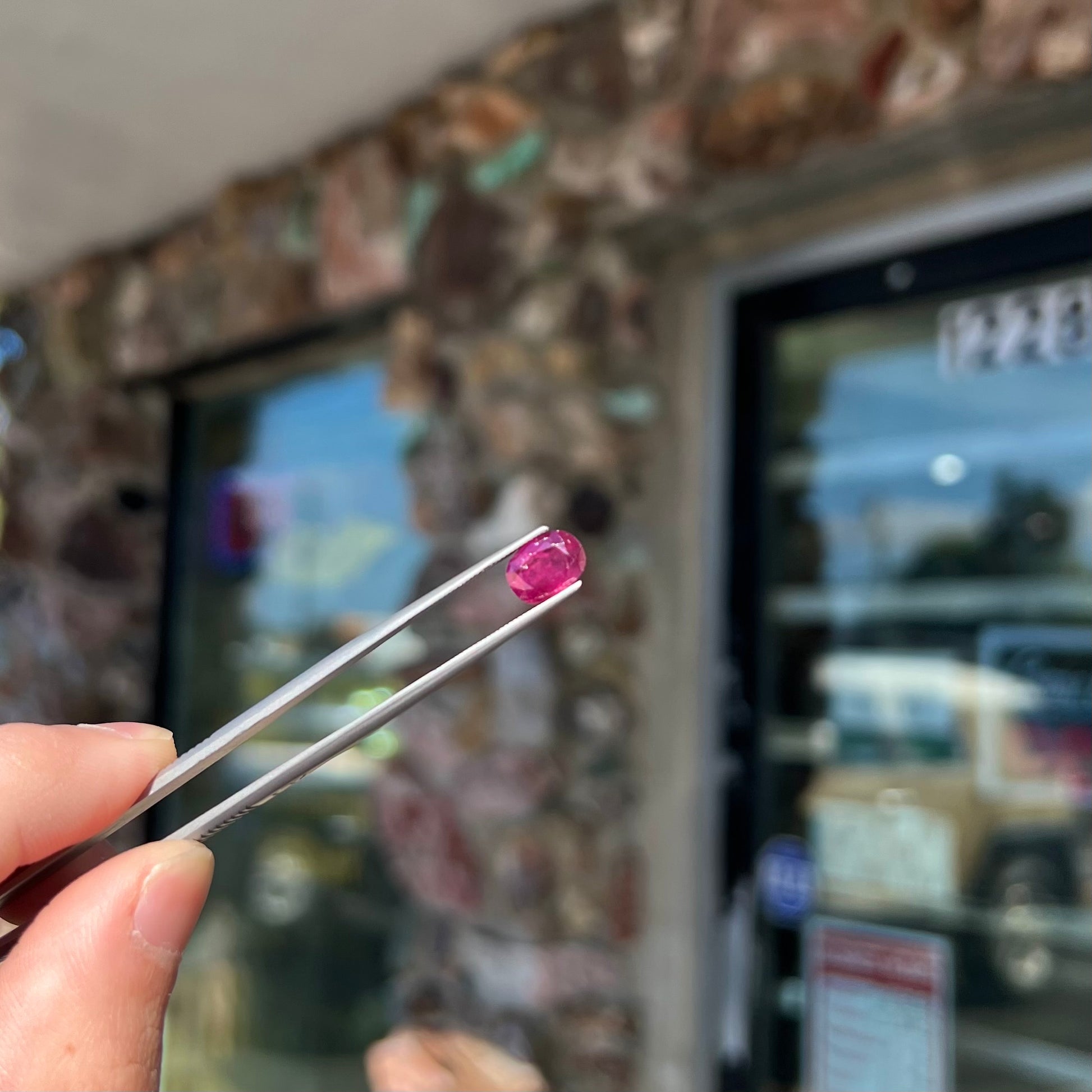 A loose, natural purplish ruby gemstone.  There is a small, minute chip on the girdle of the gem.