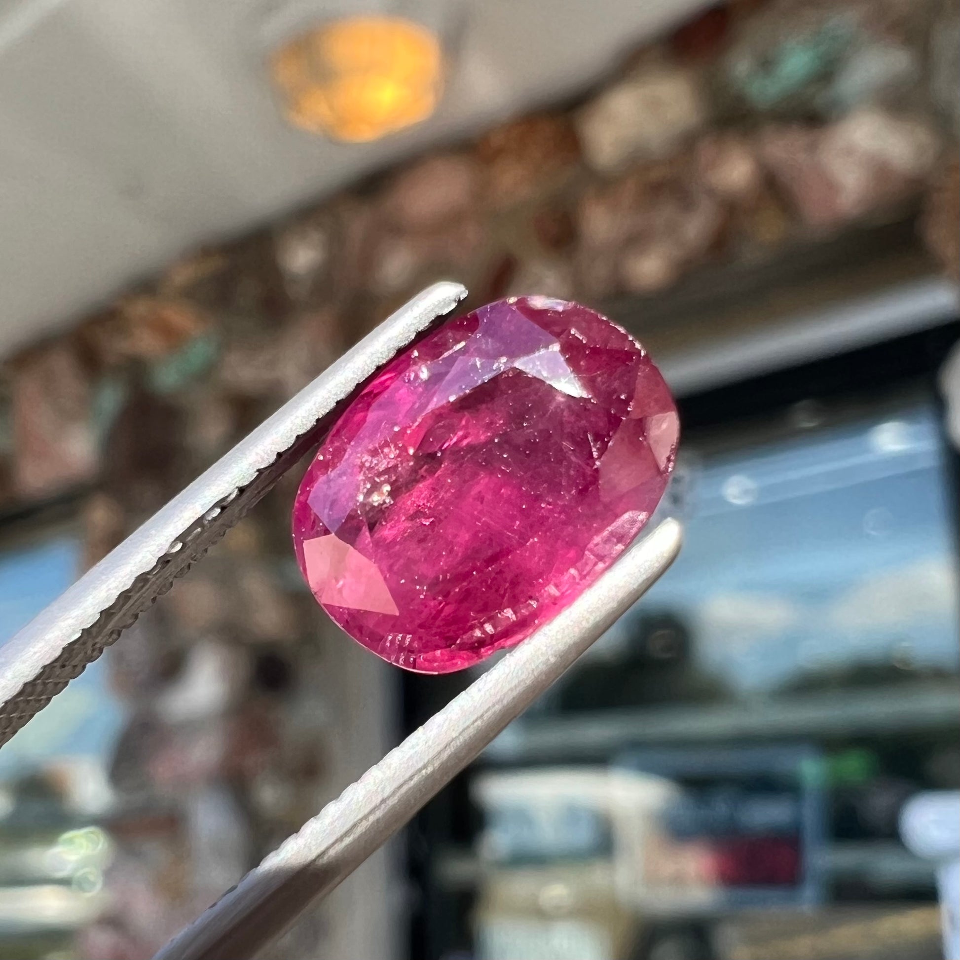 A loose, natural purplish ruby gemstone.  There is a small, minute chip on the girdle of the gem.