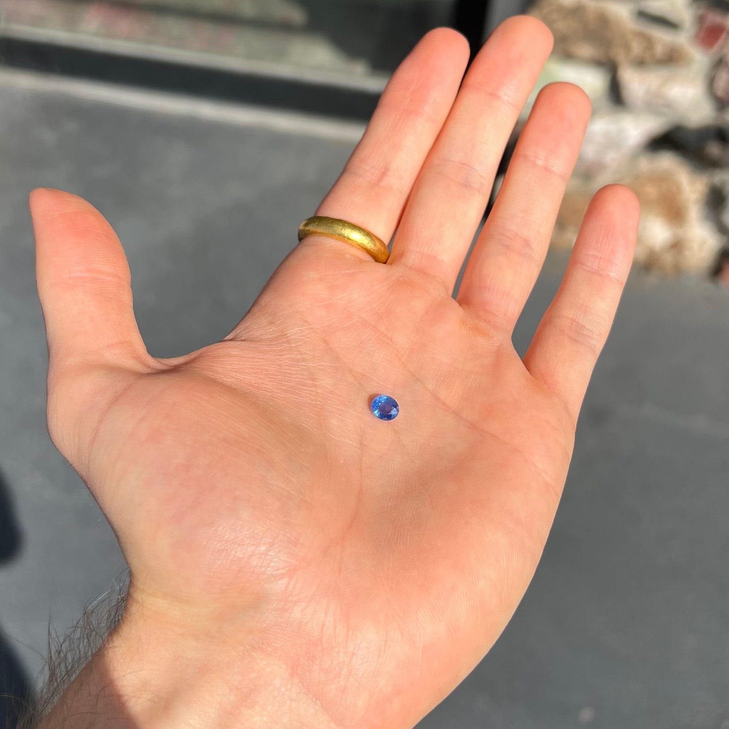 A loose, faceted oval cut natural blue sapphire.  The color is a dark cornflower blue.