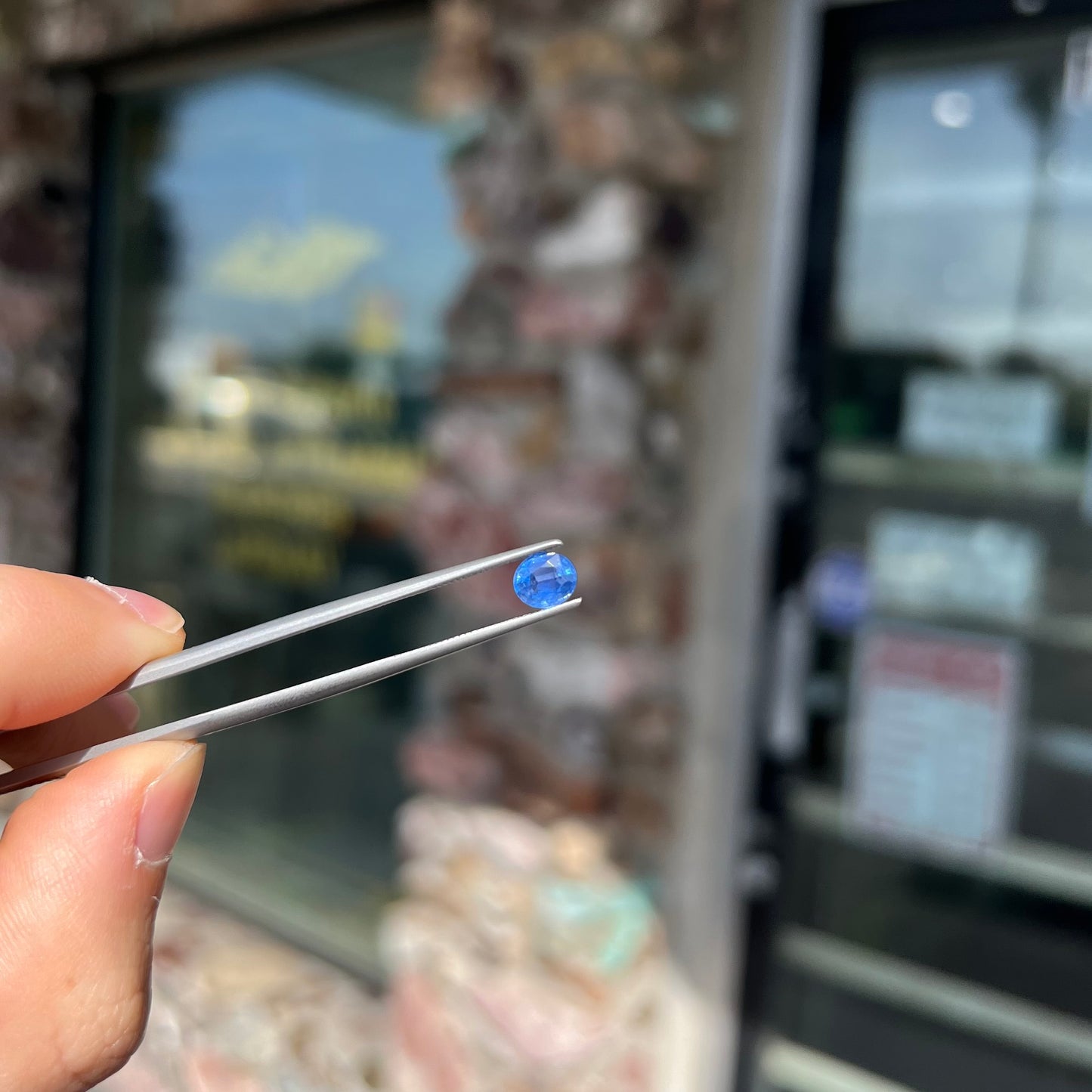 A loose, faceted oval cut natural blue sapphire. The color is a dark cornflower blue.