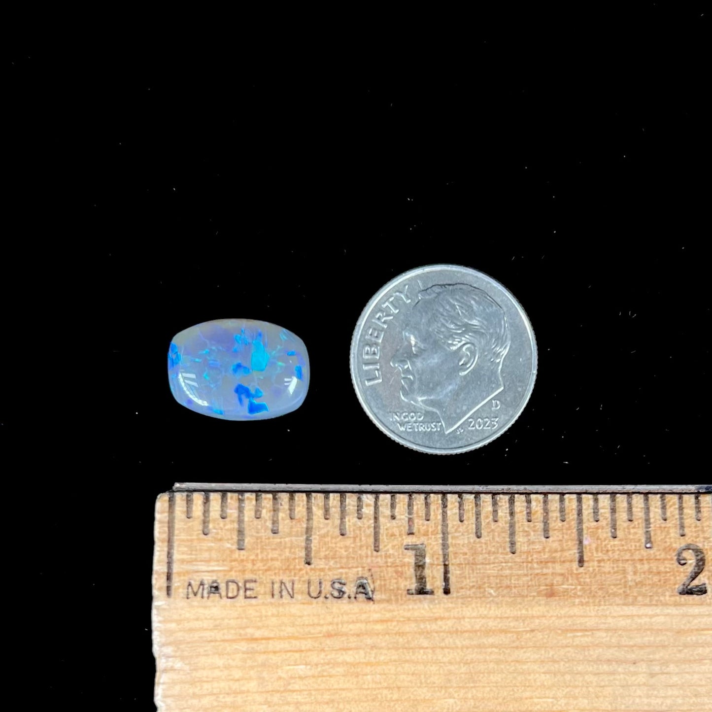 A loose, barrel shaped semi-black opal from Lightning Ridge, Australia. The opal has blue colors.