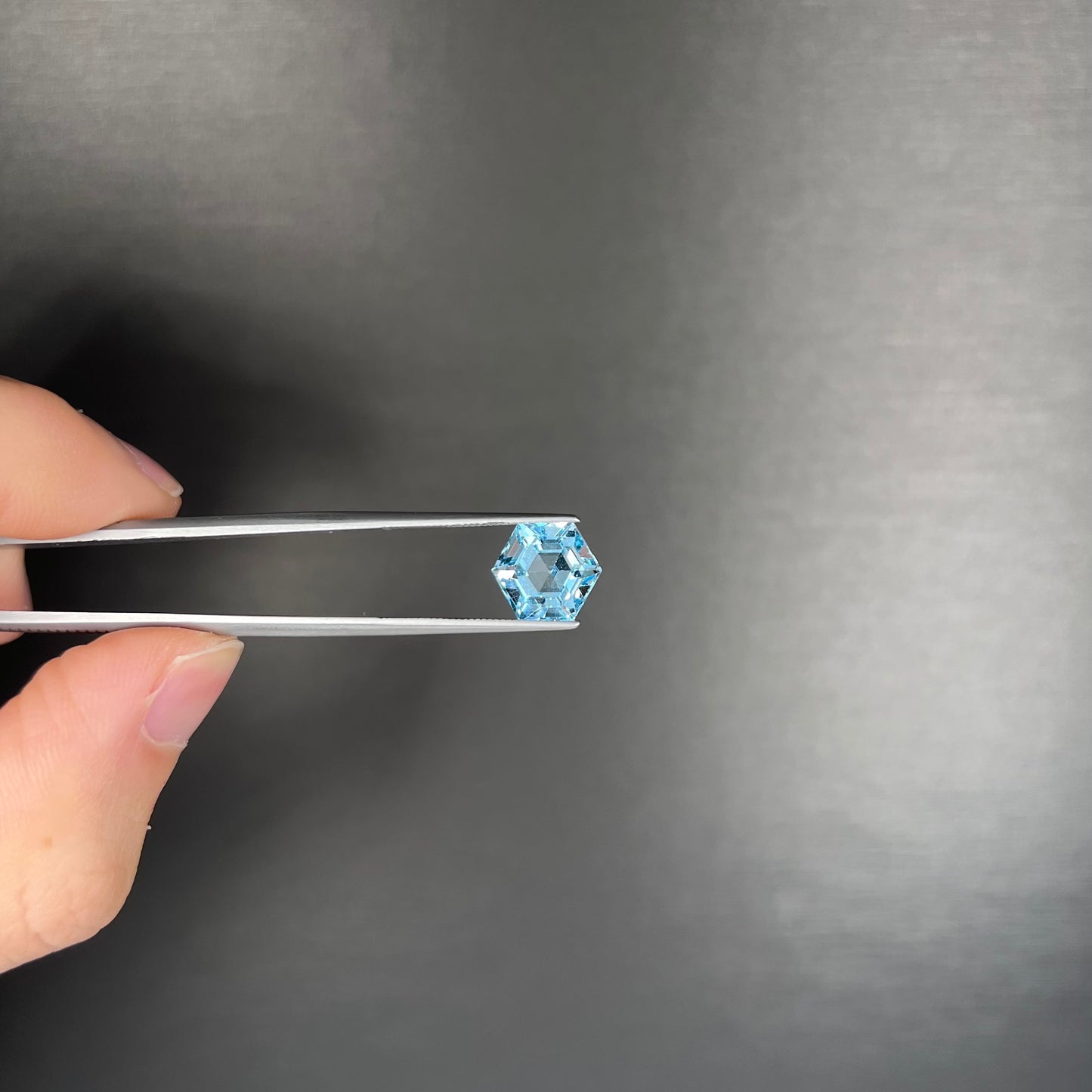 A faceted hexagon cut sky blue topaz gemstone.