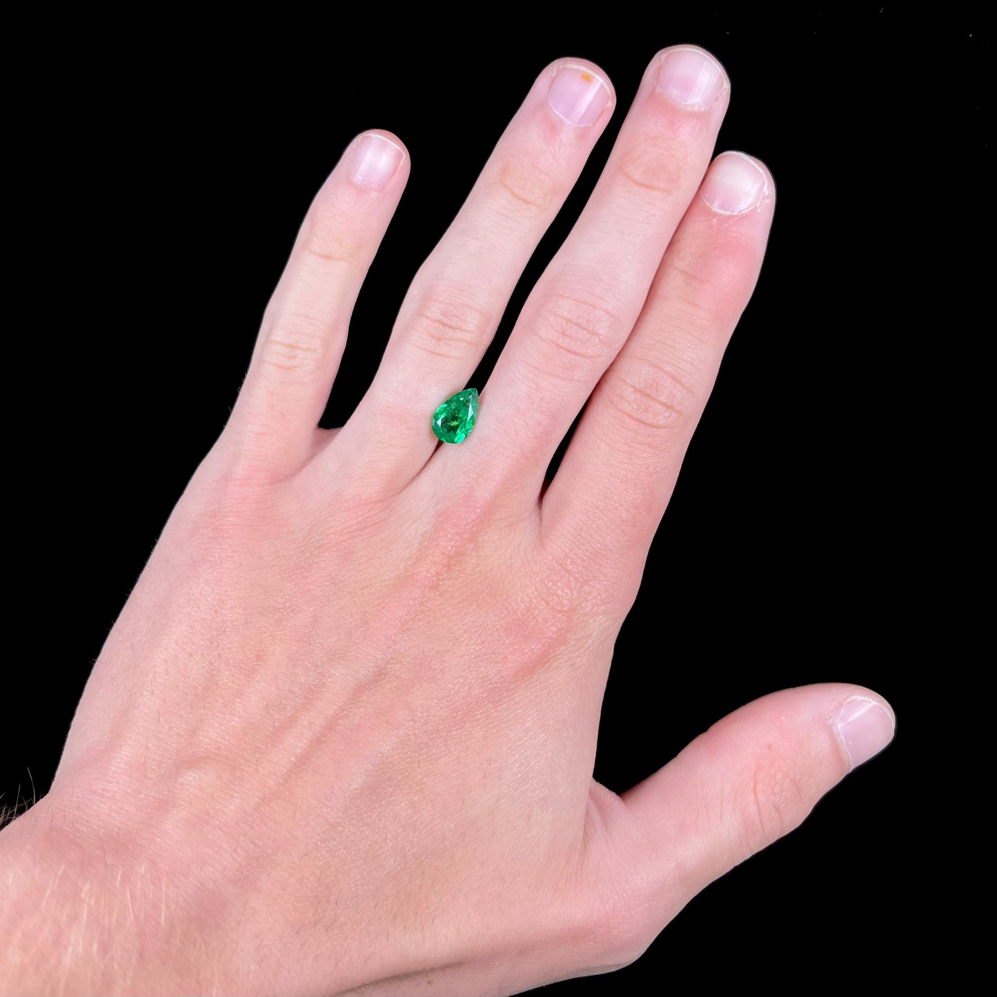 A loose, pear shaped tsavorite garnet gemstone. The stone is vivid green color.