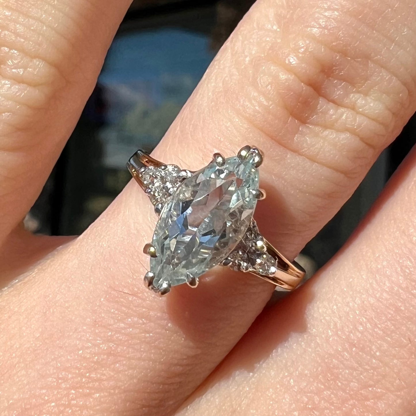 A ladies' ring set with a marquise cut aquamarine and round accent diamonds.