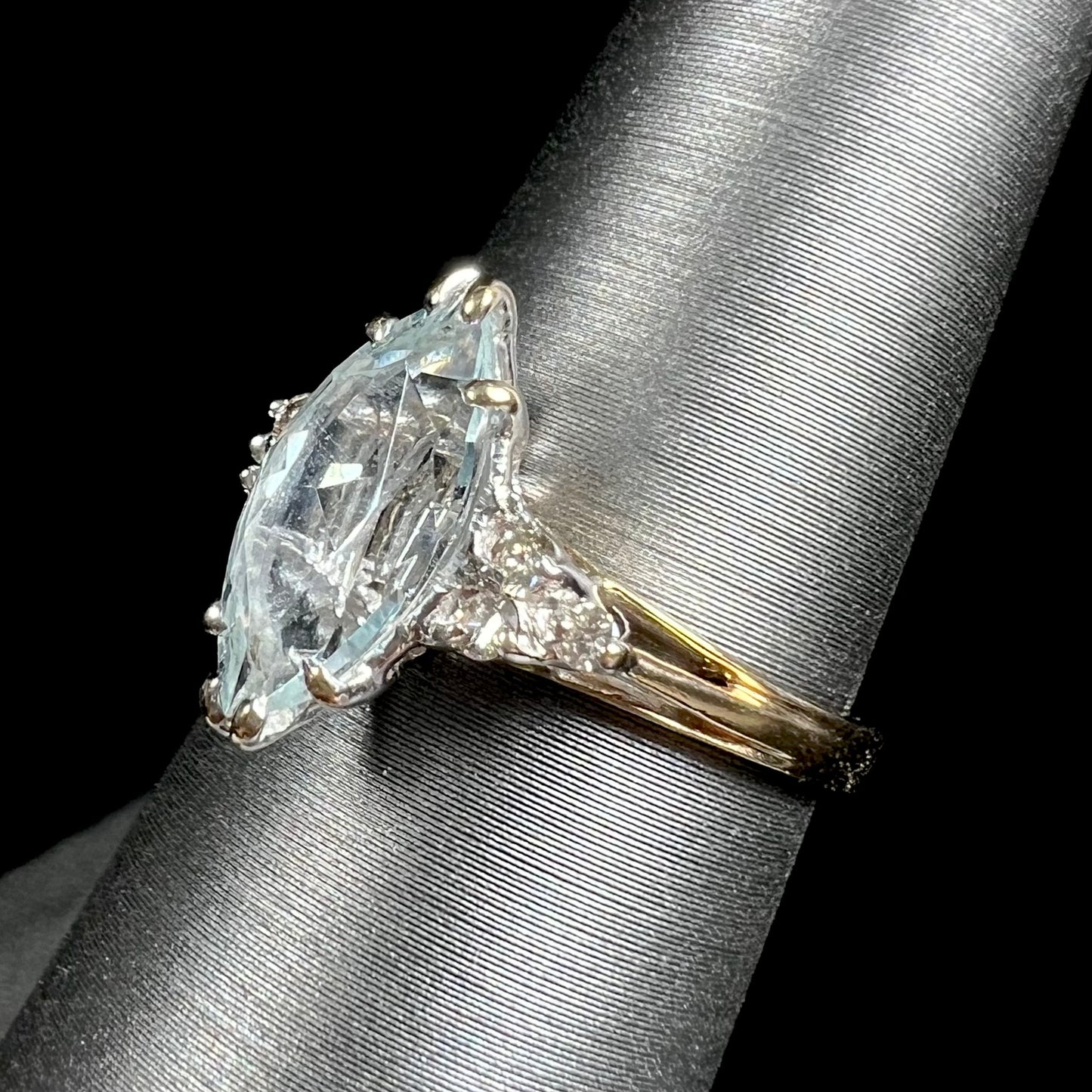 A ladies' ring set with a marquise cut aquamarine and round accent diamonds.