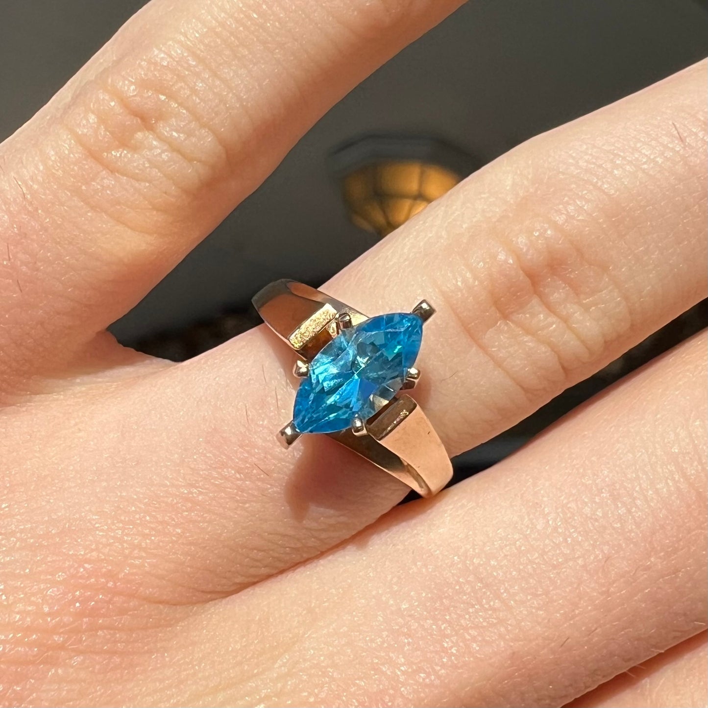 A ladies' estate yellow gold ring, prong set with a marquise cut blue topaz stone. There are scratches on the shank.