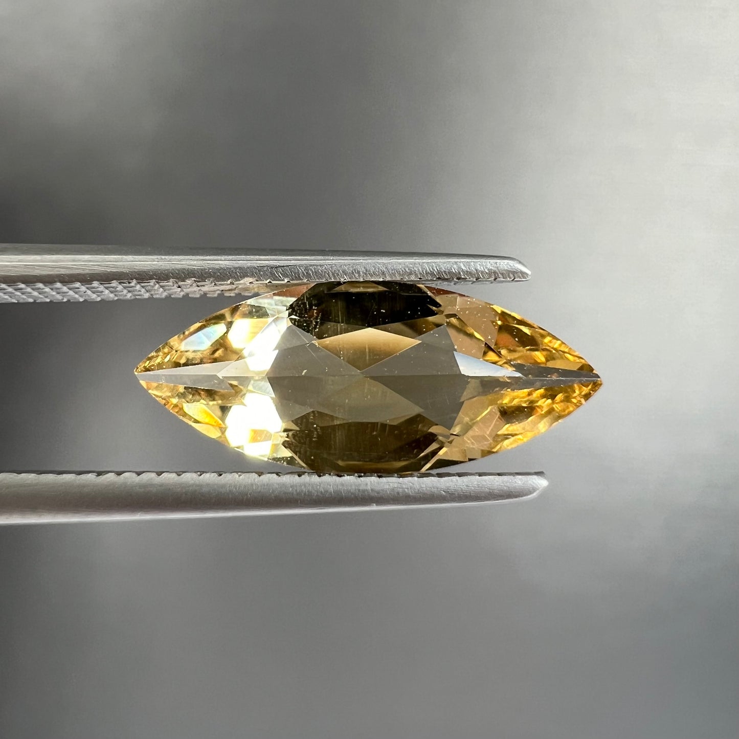 A loose, marquise cut golden beryl gemstone. The stone is a light yellow color.