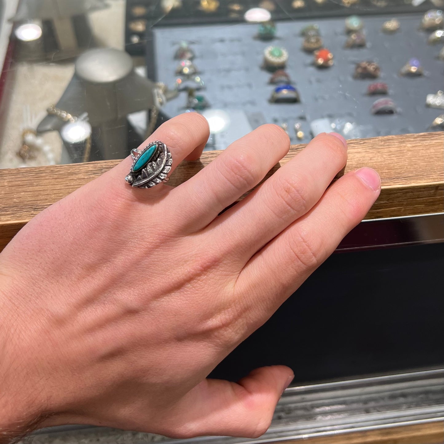 A ladies' sterling silver feather style ring set with a marquise cut turquoise stone.