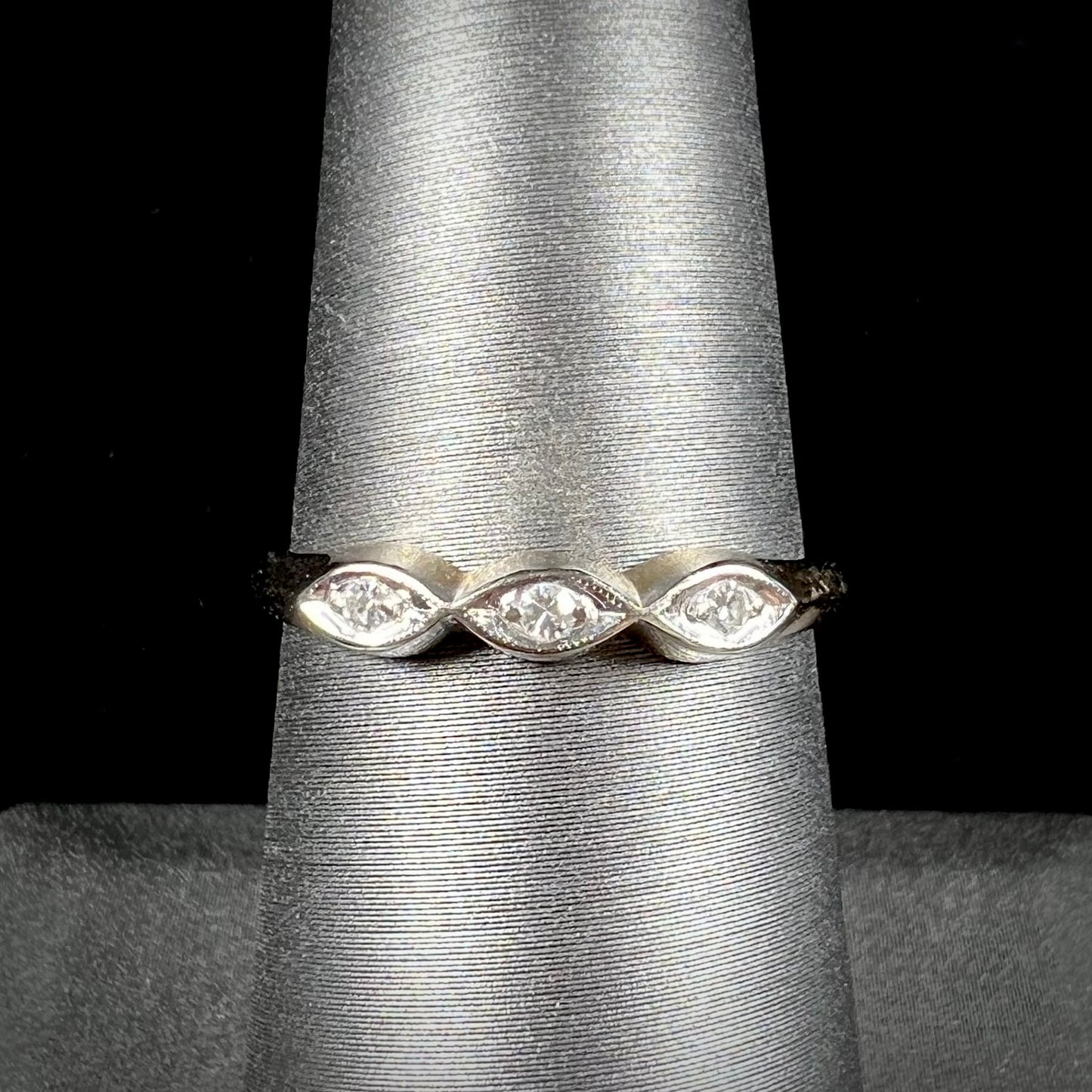 A vintage, yellow gold ladies' wedding band set with three single cut diamonds in marquise shaped designs.