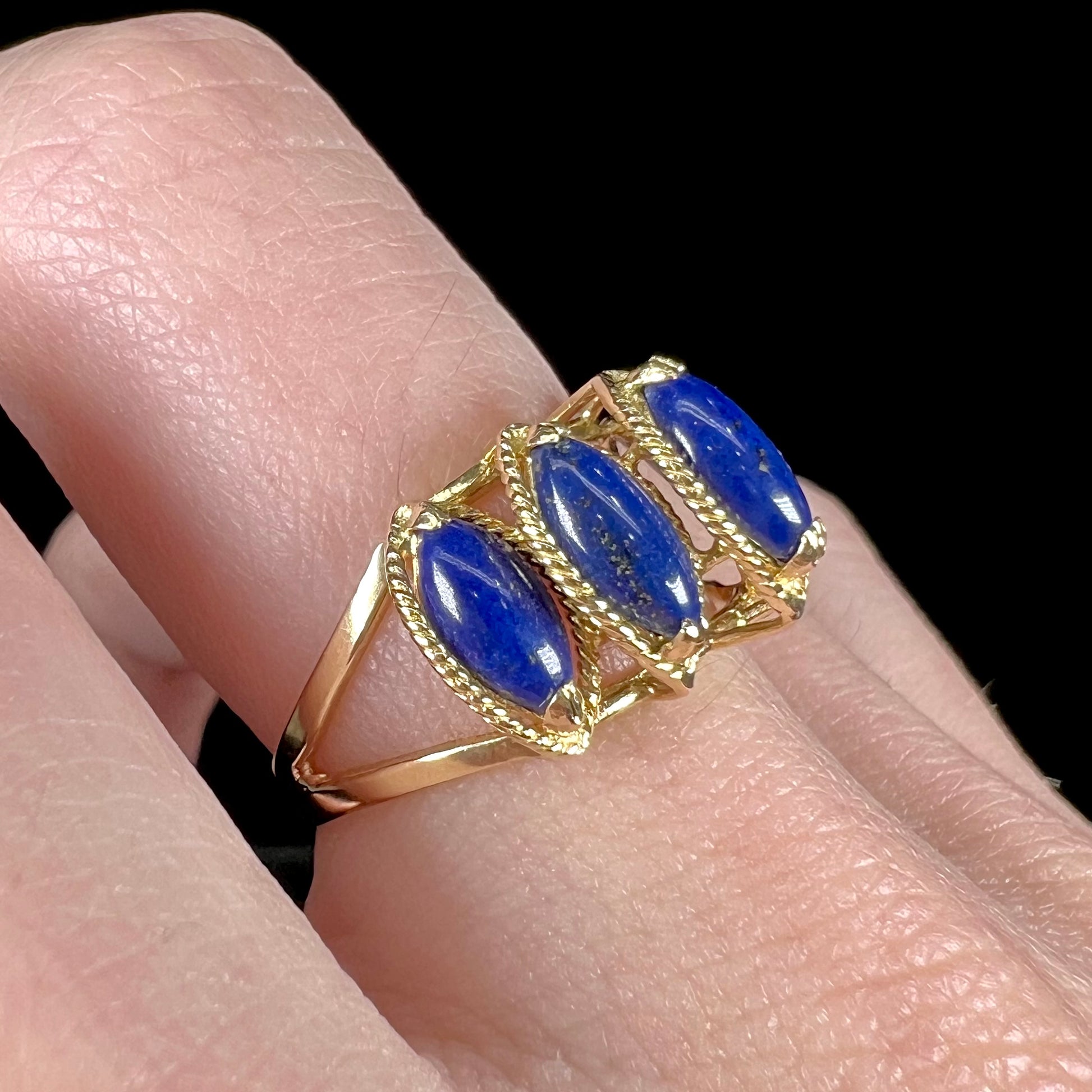A ladies' five stone marquise cabochon cut lapis lazuli ring in yellow gold.
