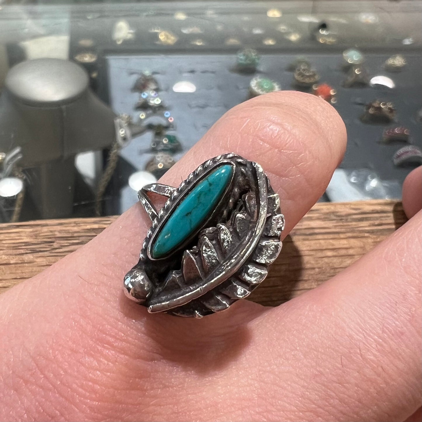 A ladies' sterling silver feather style ring set with a marquise cut turquoise stone.
