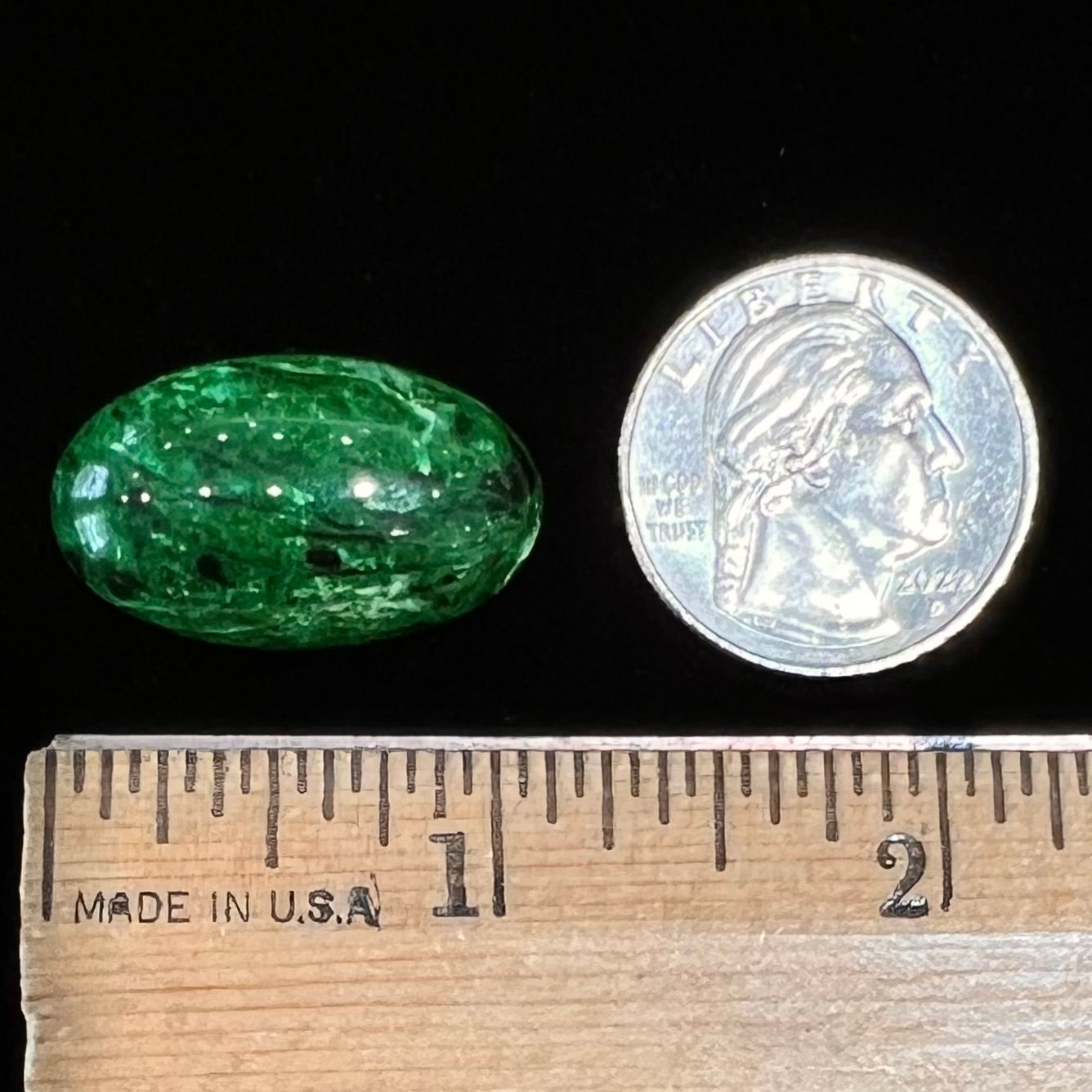A loose, oval cabochon cut green maw sit sit stone.