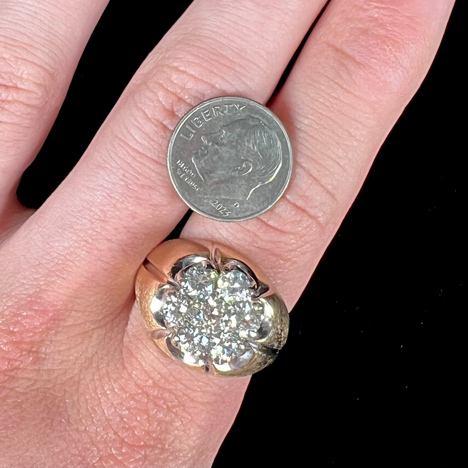 A men's textured yellow gold ring set with a cluster of seven round brilliant cut natural diamonds.