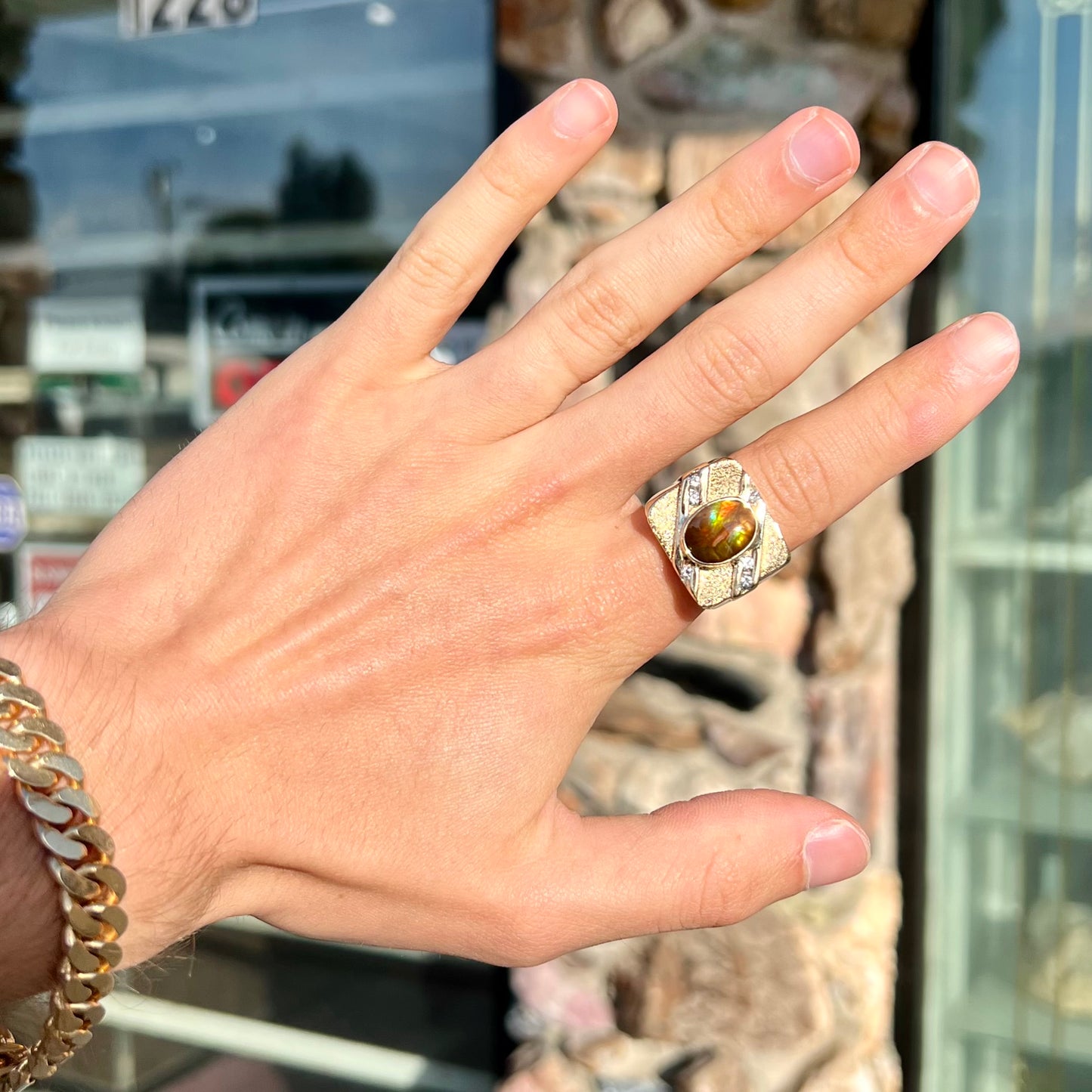 A yellow gold men's ring channel set with diamonds and bezel set with a Mexican fire agate stone.