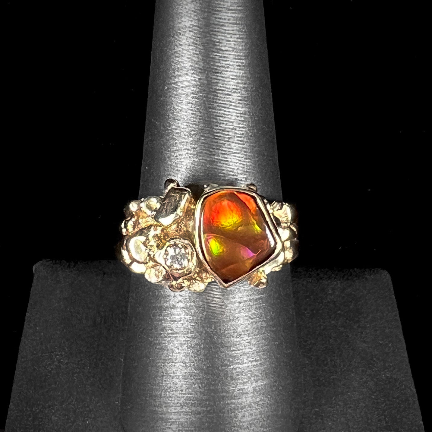 A men's yellow gold, nugget style ring set with a Mexican fire agate stone and a diamond accent.