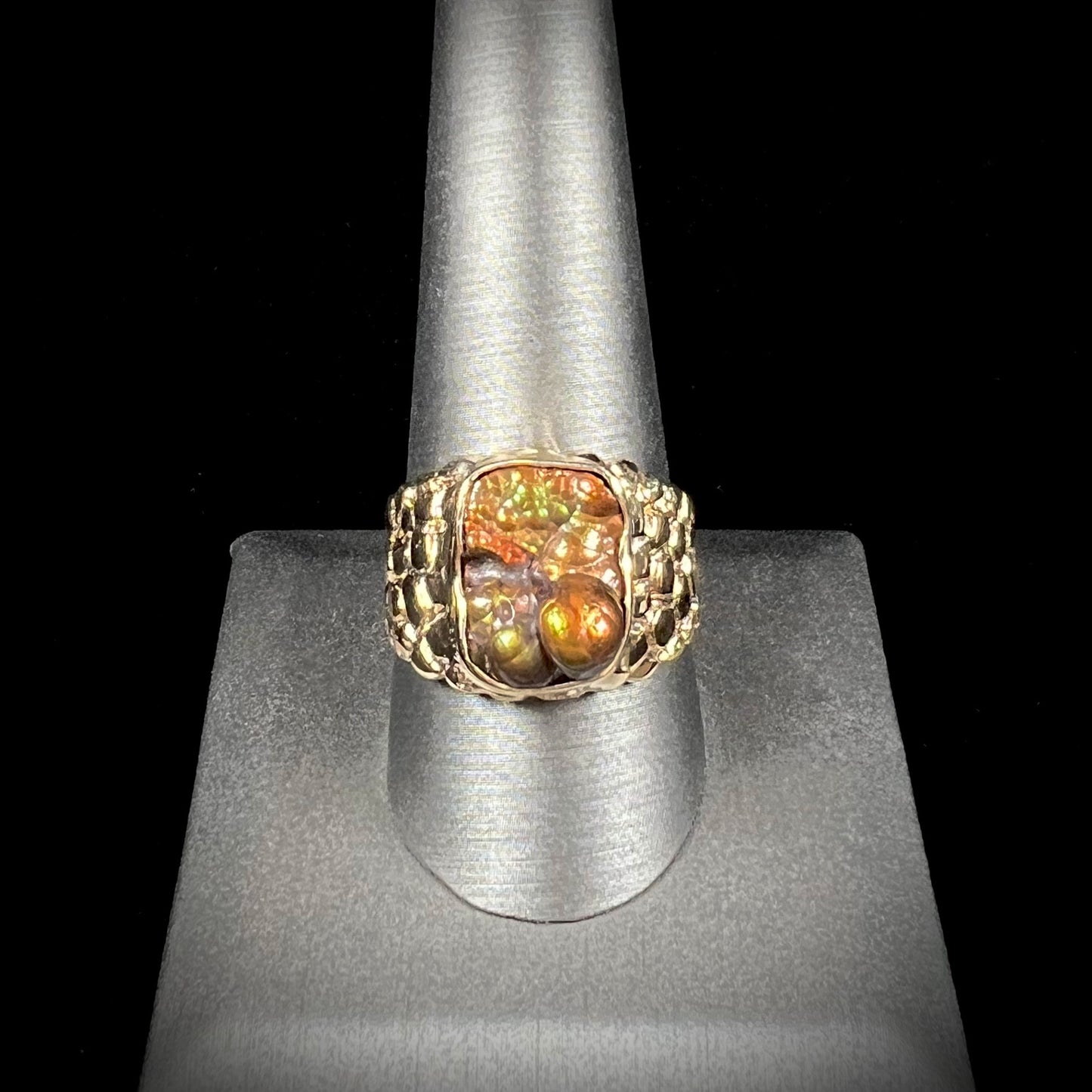 A men's yellow gold, nugget style ring set with a bubbly, California fire agate stone.