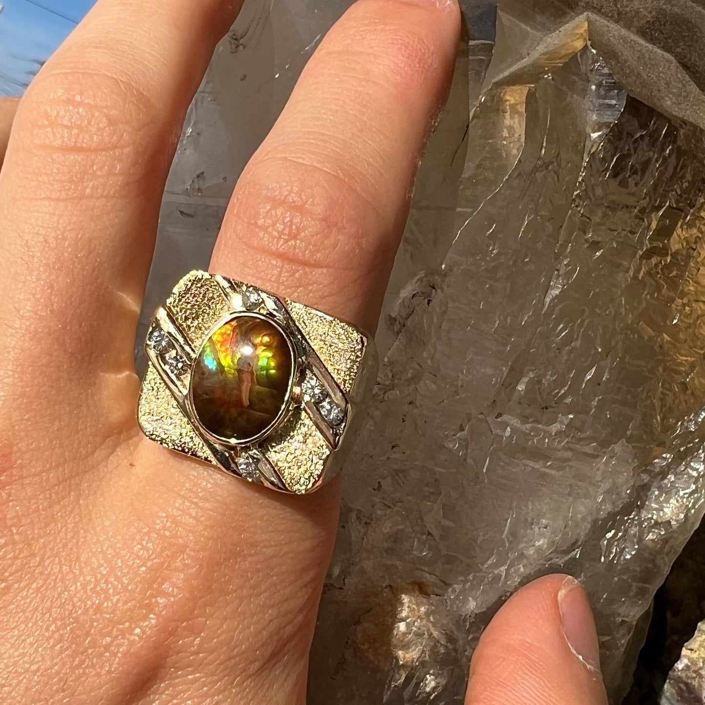 A yellow gold men's ring channel set with diamonds and bezel set with a Mexican fire agate stone.