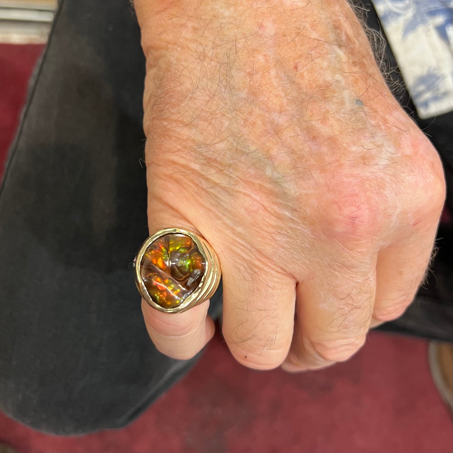 A men's heavy yellow gold ring set with a Mexican fire agate stone and three round brilliant cut diamond accents.