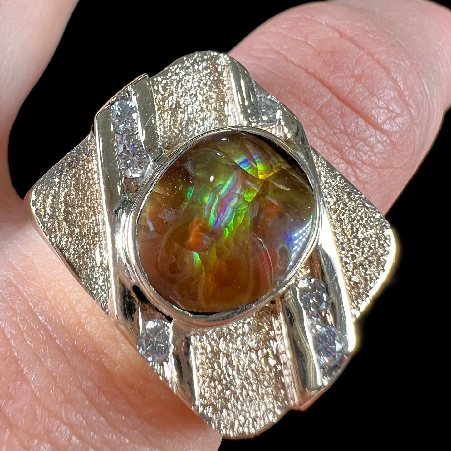 A yellow gold men's ring channel set with diamonds and bezel set with a Mexican fire agate stone.