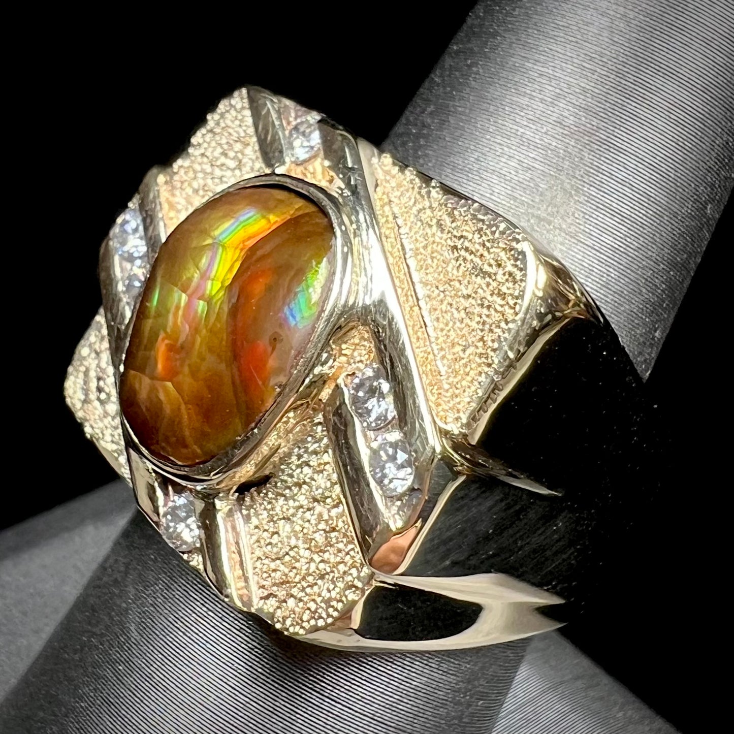 A yellow gold men's ring channel set with diamonds and bezel set with a Mexican fire agate stone.