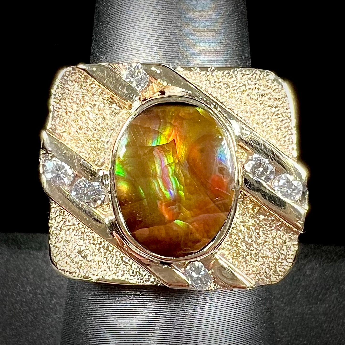 A yellow gold men's ring channel set with diamonds and bezel set with a Mexican fire agate stone.