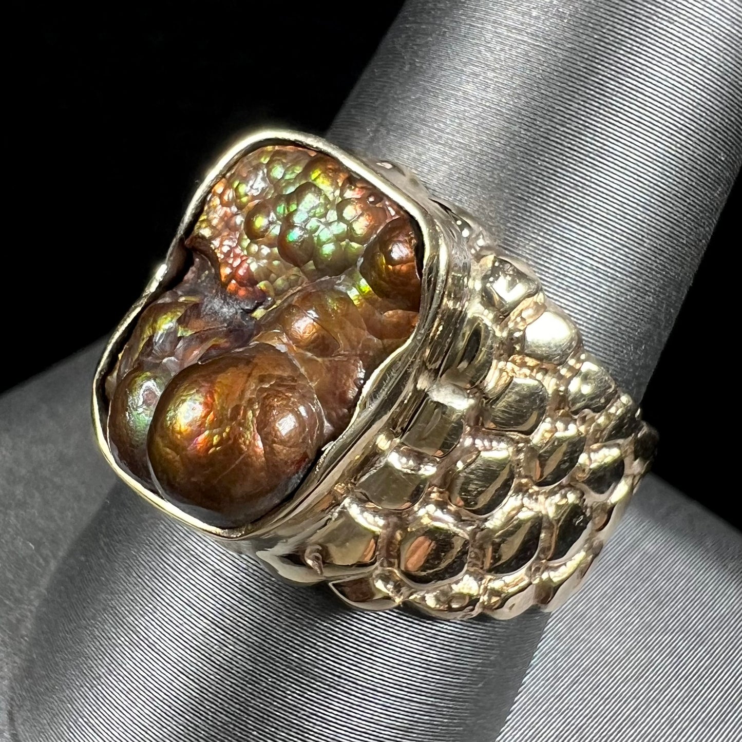 A men's yellow gold, nugget style ring set with a bubbly, California fire agate stone.