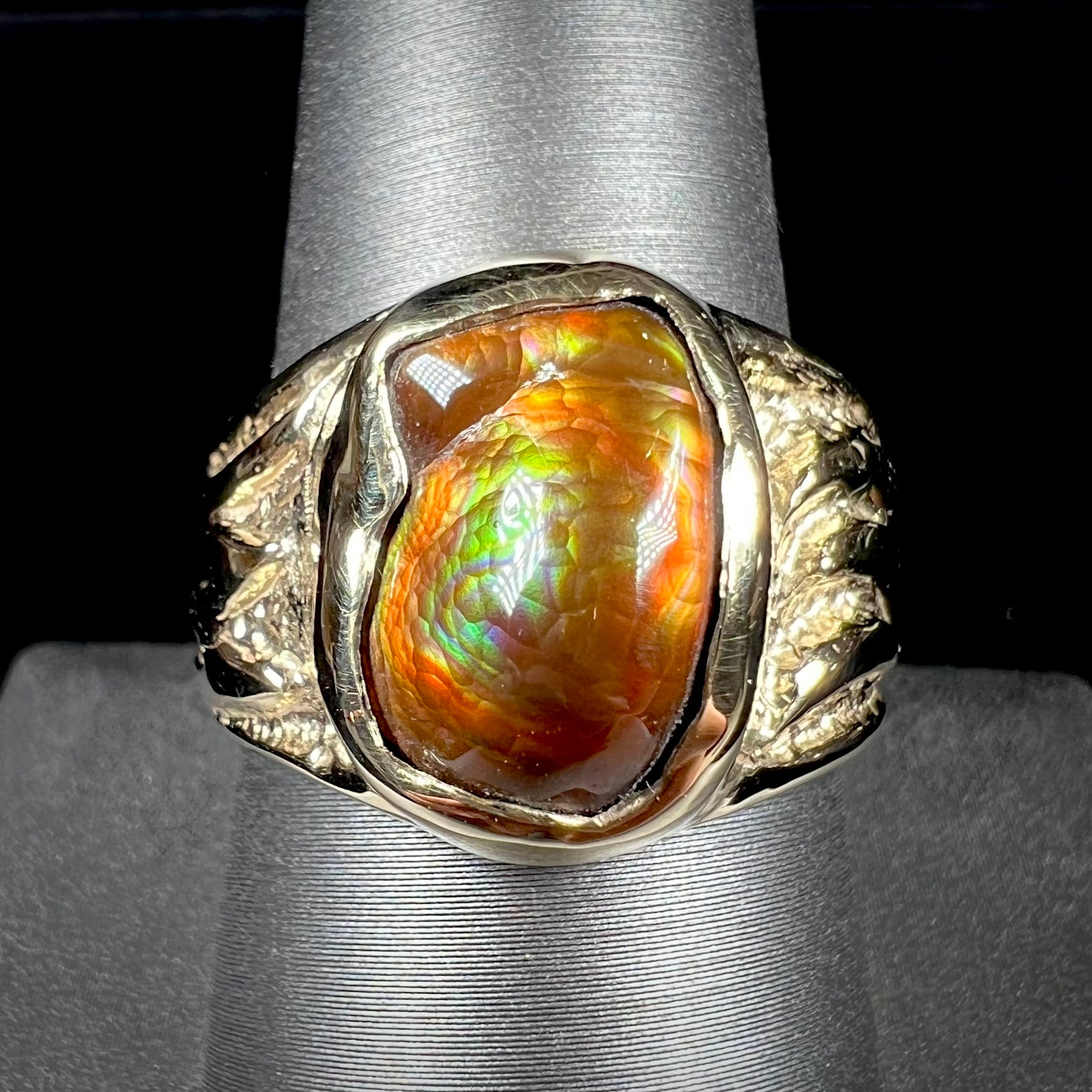 A man's yellow gold solitaire ring set with a freeform shaped Mexican fire agate stone.  The stone has a purple bull's eye pattern.
