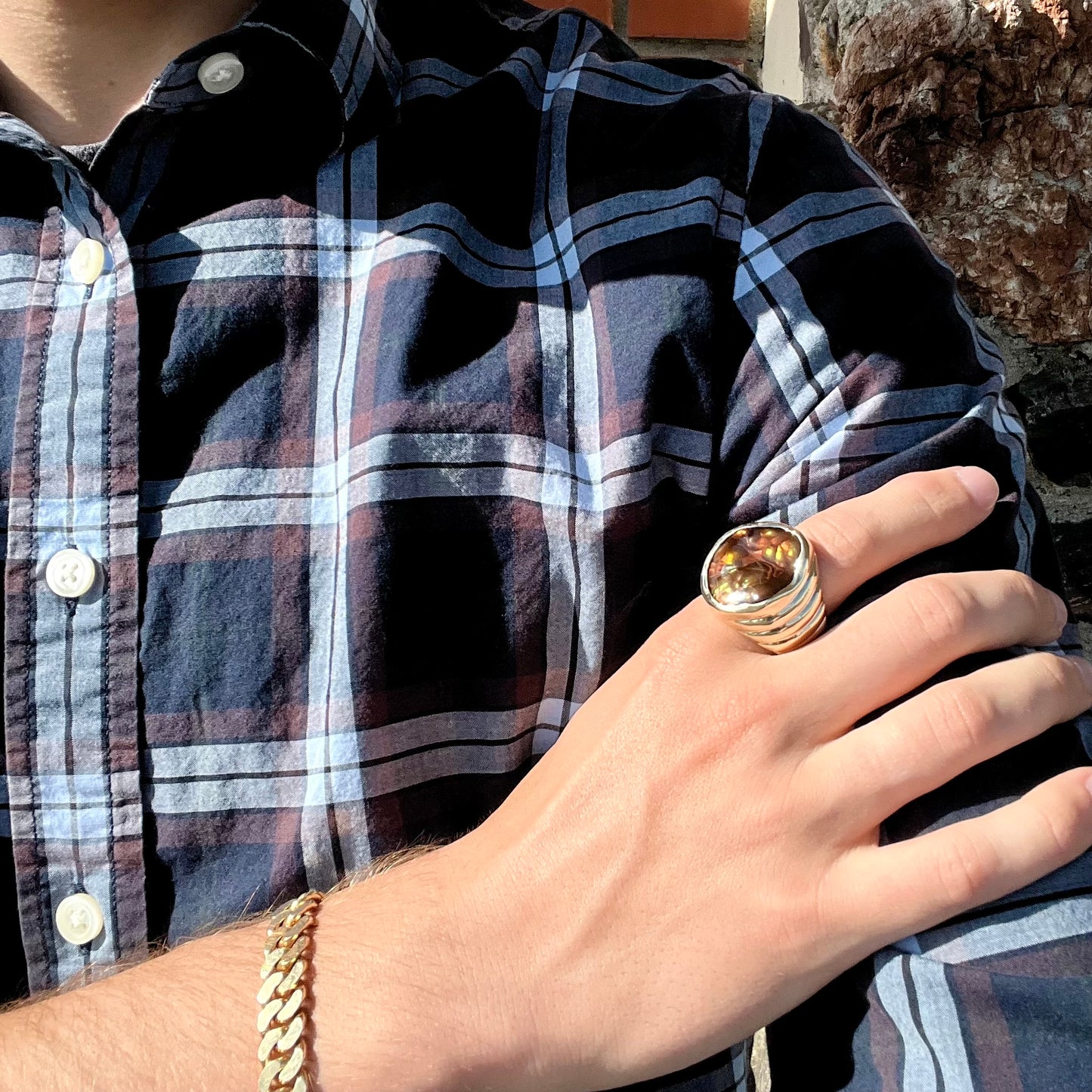 A men's heavy yellow gold ring set with a Mexican fire agate stone and three round brilliant cut diamond accents.