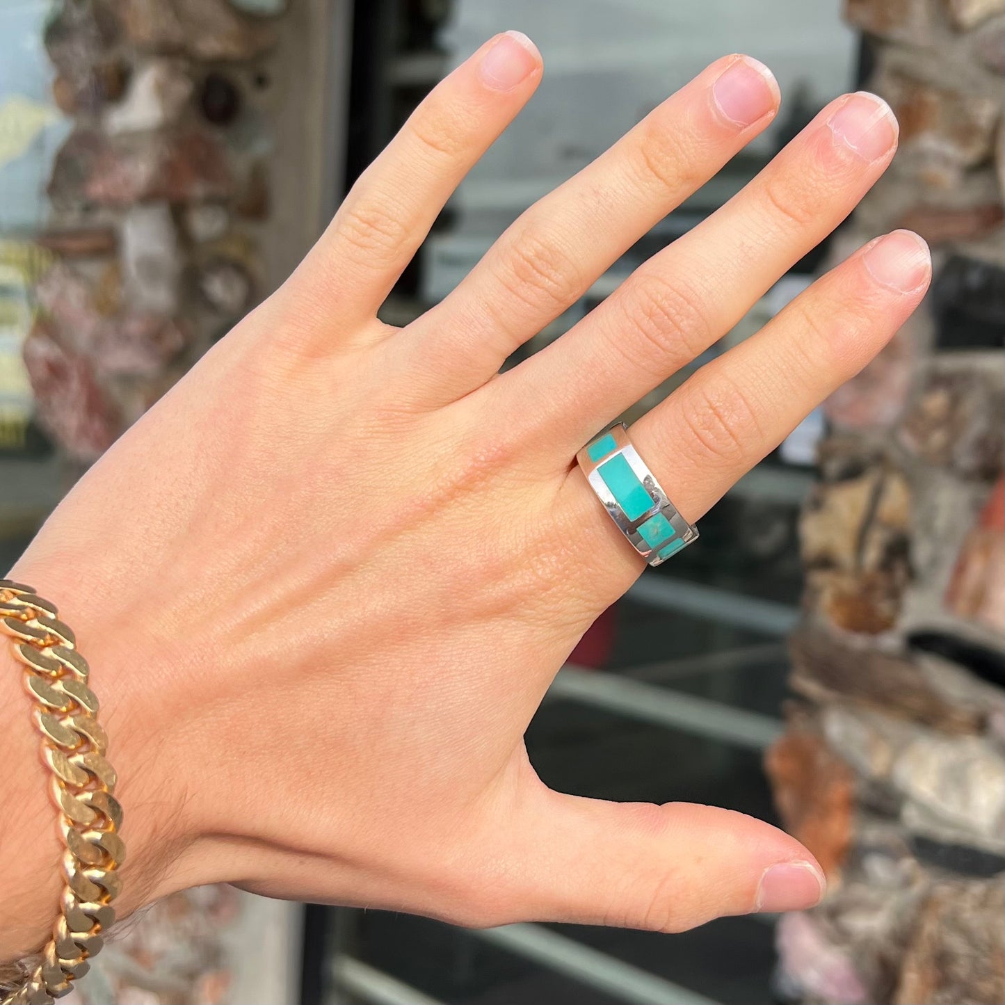 A men's sterling silver wedding band inlaid with natural Sleeping Beauty Turquoise stones that go all the way around.