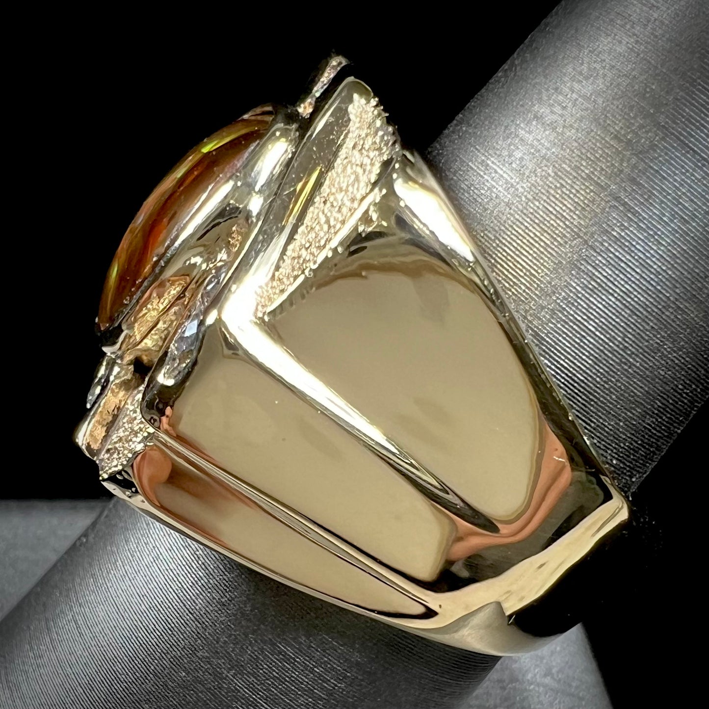 A yellow gold men's ring channel set with diamonds and bezel set with a Mexican fire agate stone.