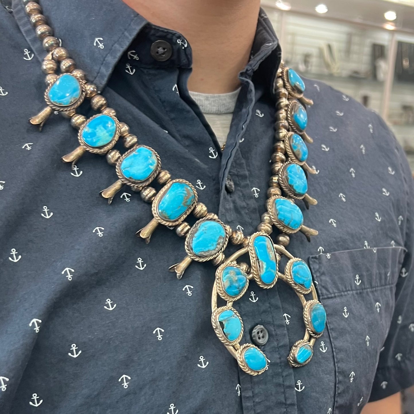 A vintage Navajo squash blossom necklace set with blue Kingman turquoise stones.