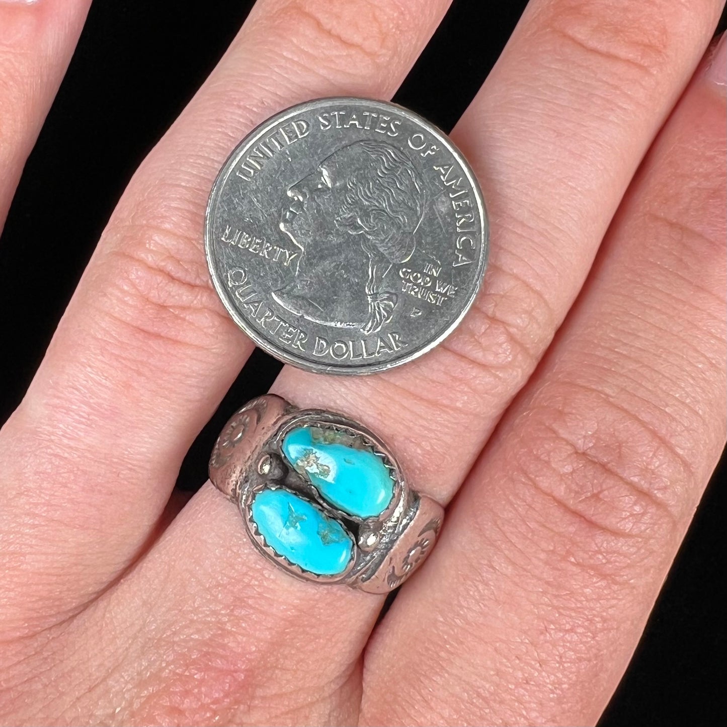 A unisex sterling silver ring bezel set with two Pilot Mountain turquoise stones.  The ring is stamped with sun patterns.