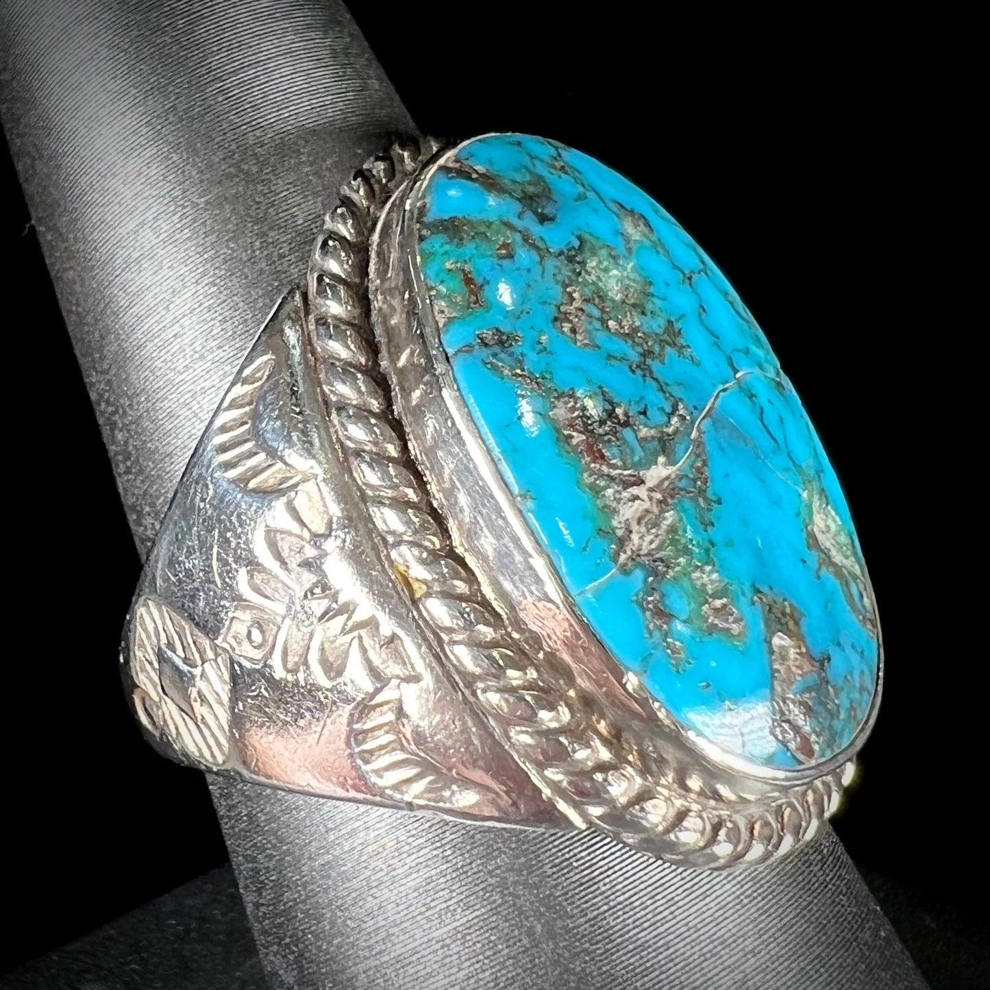 A men's sterling silver Morenci turquoise solitaire ring. The ring has a Southwest Navajo style stamp pattern.