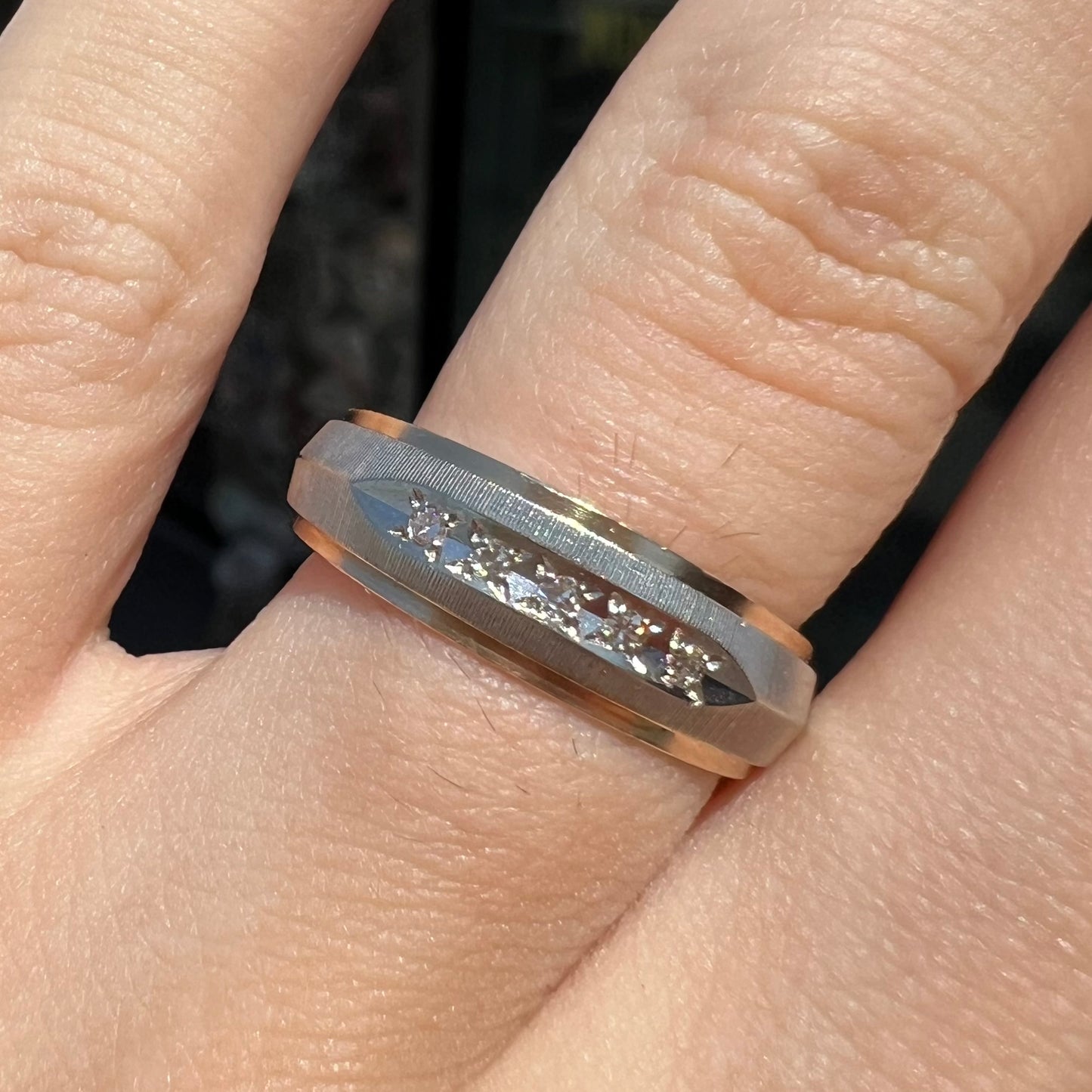 A unisex, two-tone white and yellow gold diamond wedding band. The white gold is textured.