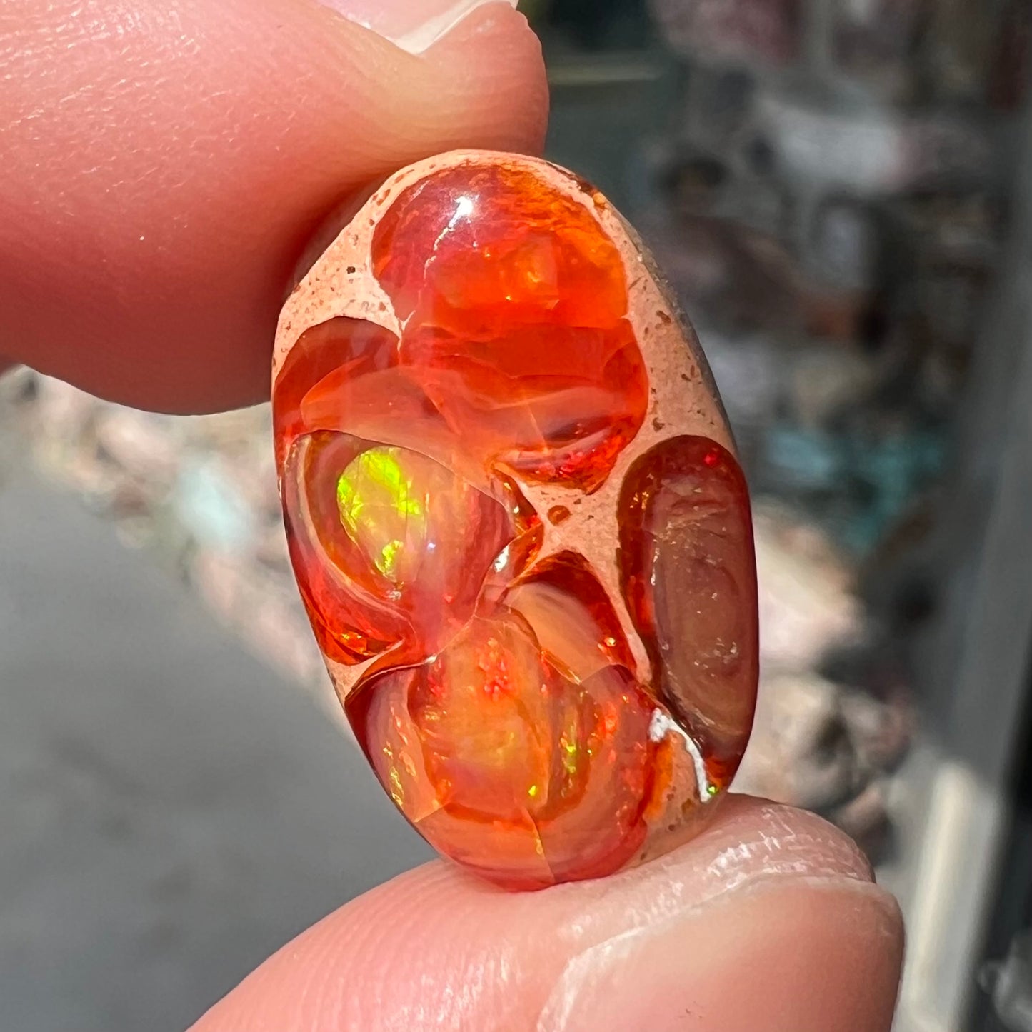 A loose Mexican matrix fire opal stone. The opal is orange with green flashes.
