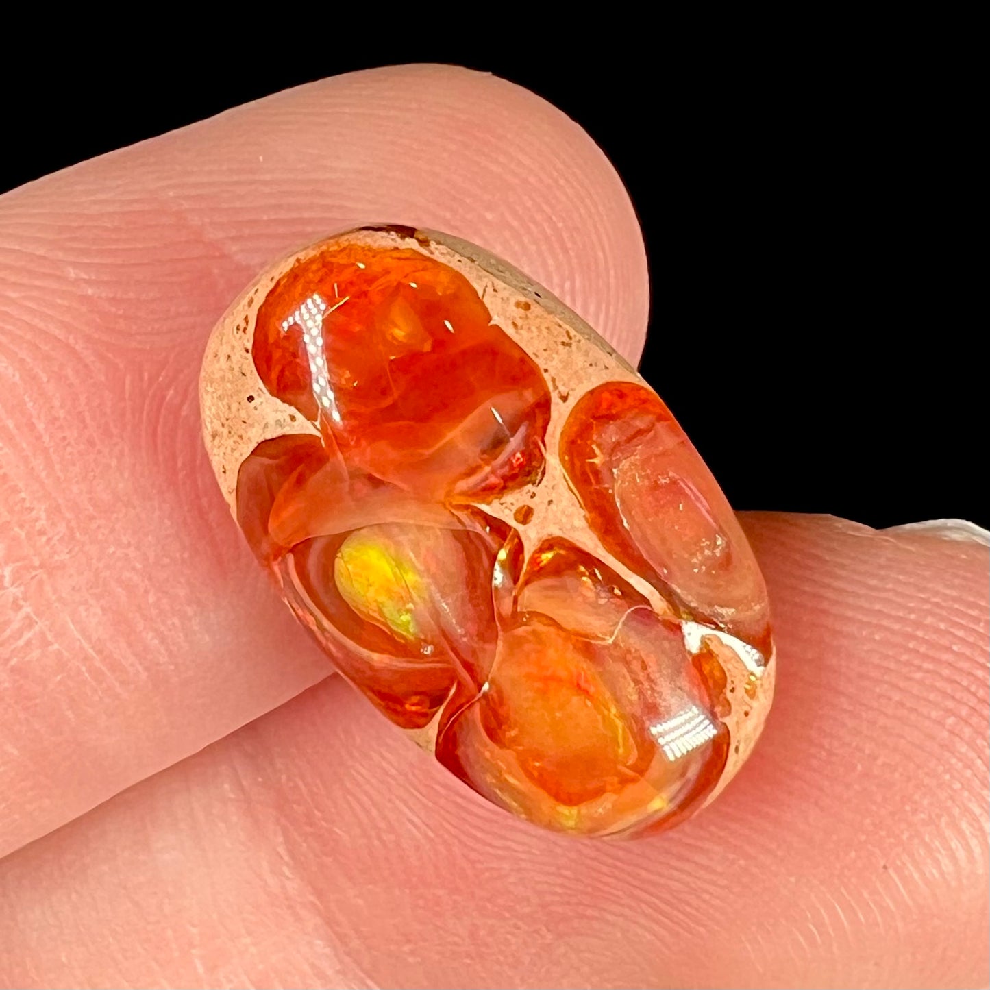 A loose Mexican matrix fire opal stone. The opal is orange with green flashes.