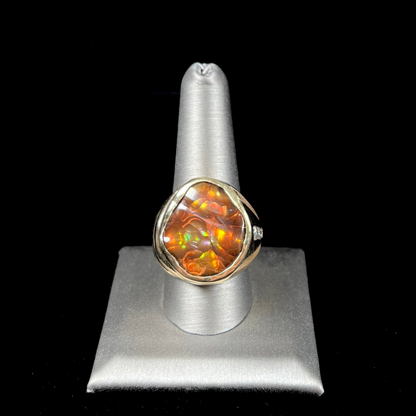 A men's heavy yellow gold ring set with a Mexican fire agate stone and three round brilliant cut diamond accents.