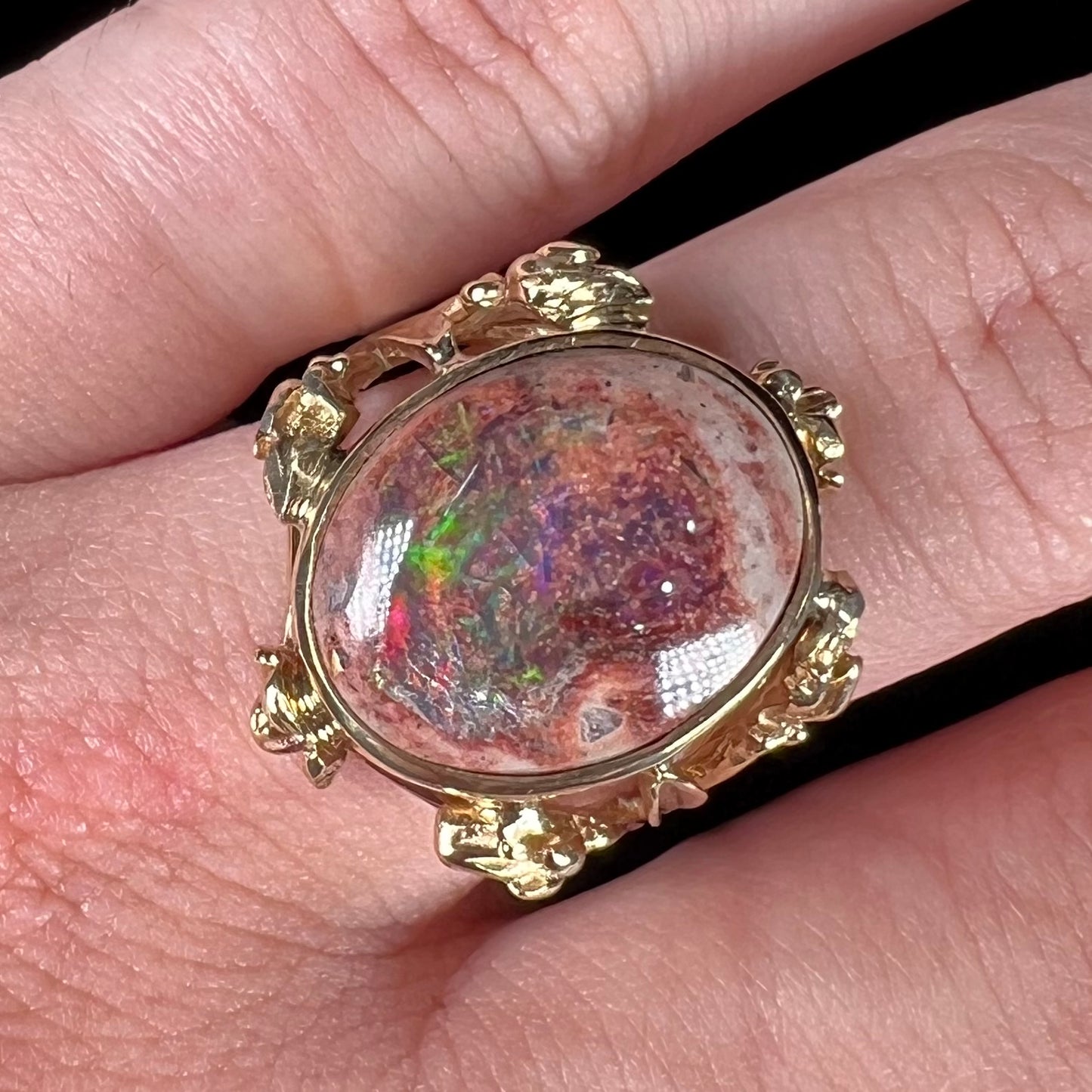 A ladies' estate yellow gold solitaire ring set with an oval cabochon cut natural Cantera fire opal.