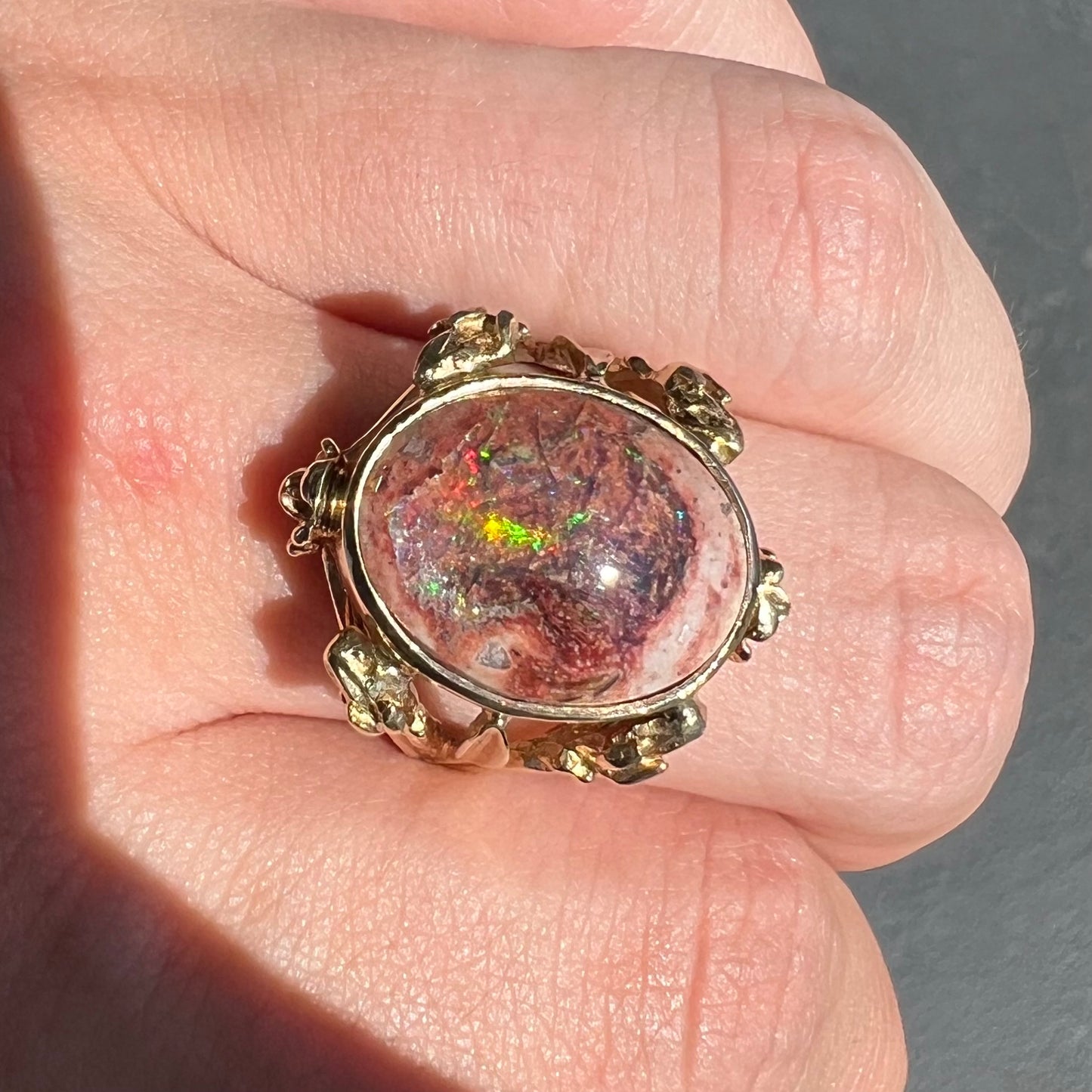 A ladies' estate yellow gold solitaire ring set with an oval cabochon cut natural Cantera fire opal.