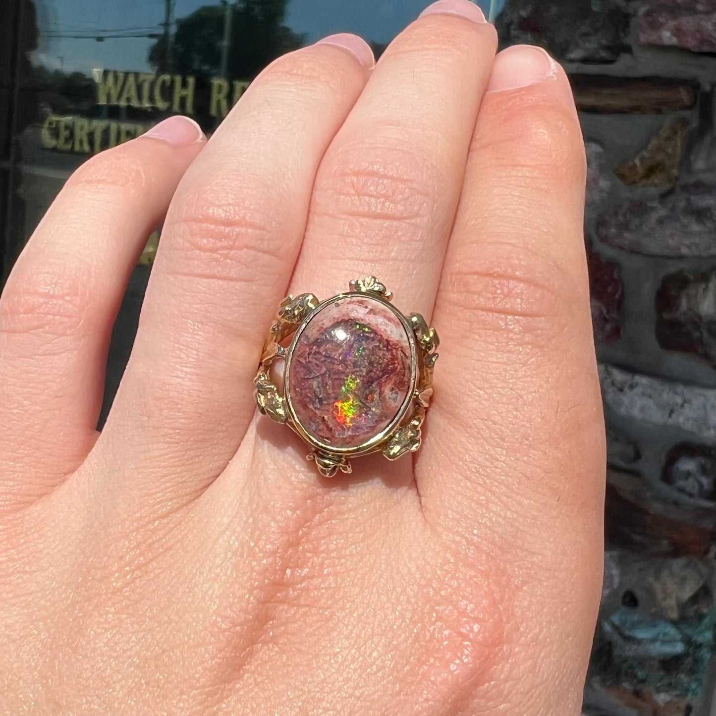 A ladies' estate yellow gold solitaire ring set with an oval cabochon cut natural Cantera fire opal.