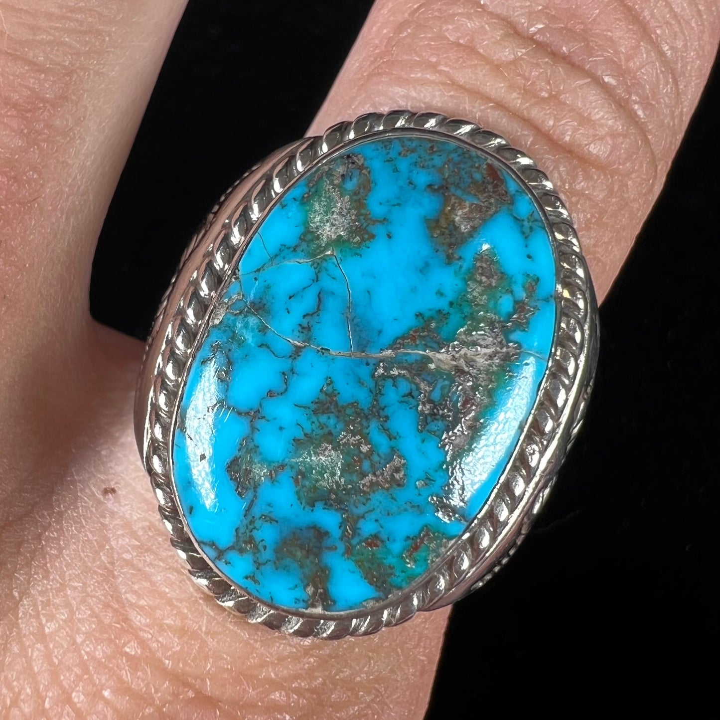 A men's sterling silver Morenci turquoise solitaire ring. The ring has a Southwest Navajo style stamp pattern.
