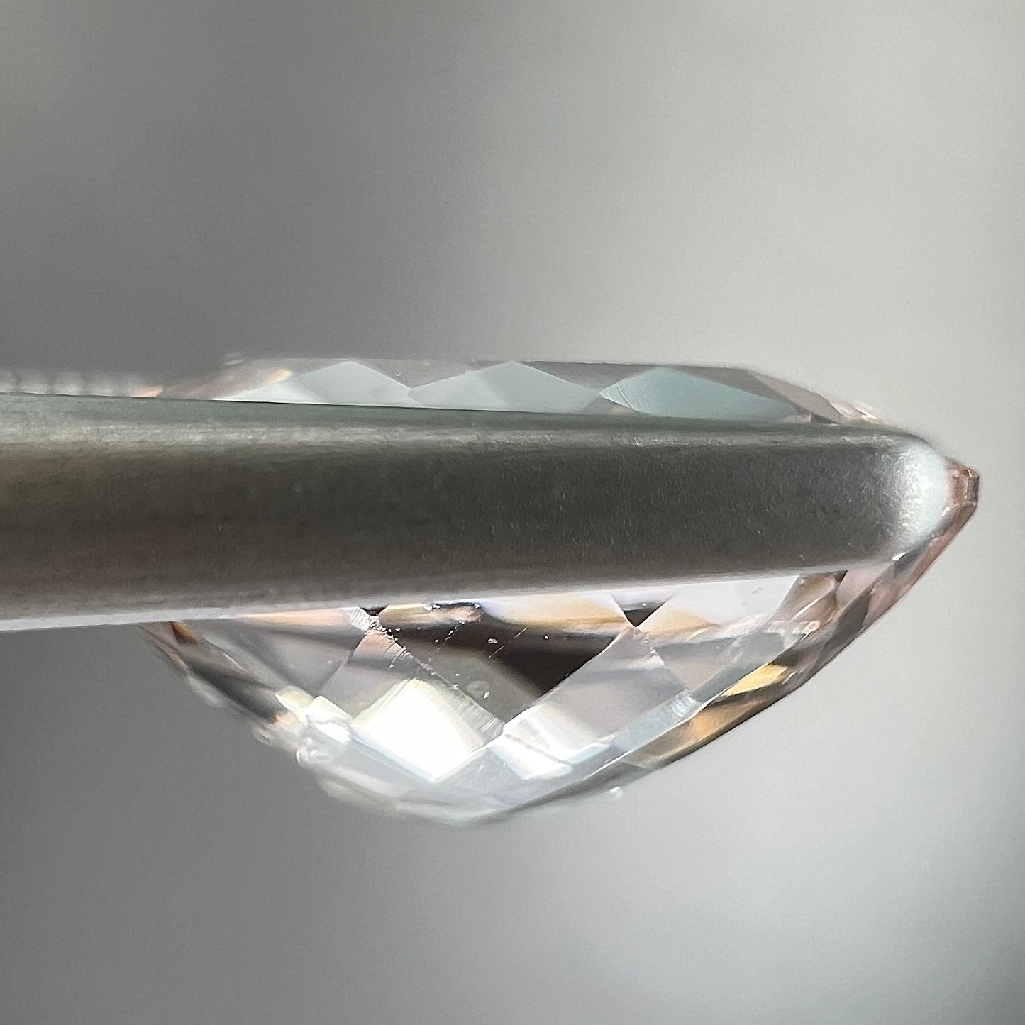 A loose, faceted oval cut pink morganite gemstone.