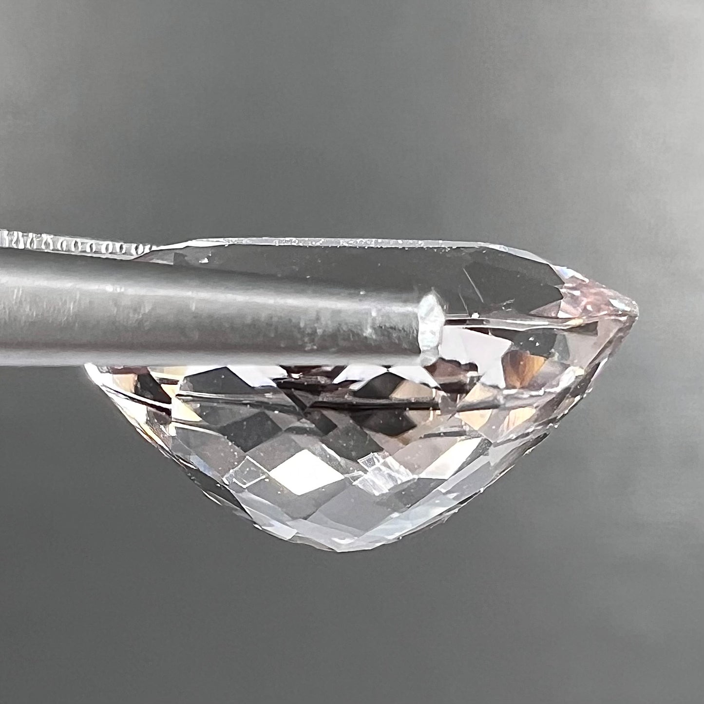 A loose, faceted oval cut pink morganite gemstone.