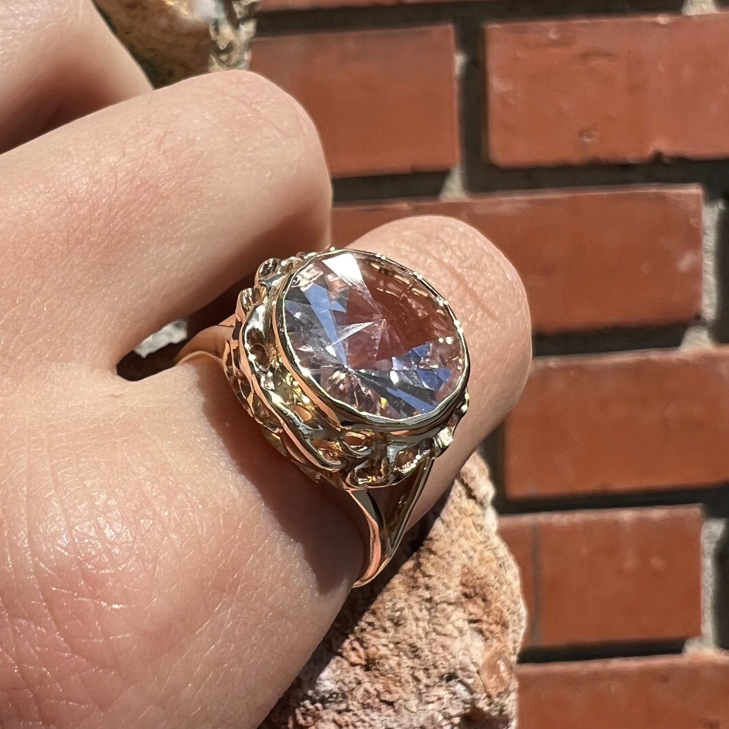 A ladies' yellow gold solitaire ring bezel set with a modified bud cut morganite gemstone.